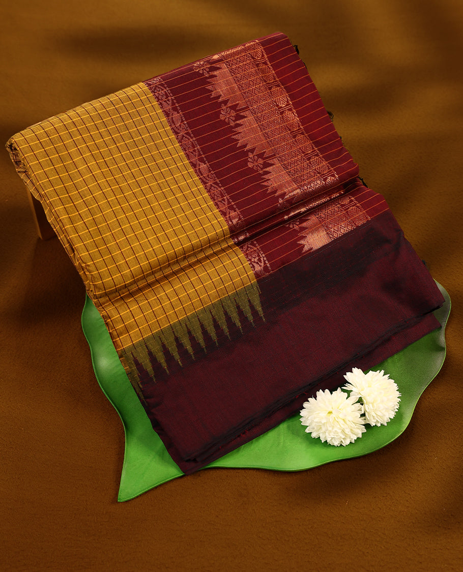 Bright Mustard colour mixed Kalyani cotton saree featuring Maroon Checks throughout the body, paired with a Maroon colour traditional border and pallu, with matching blouse