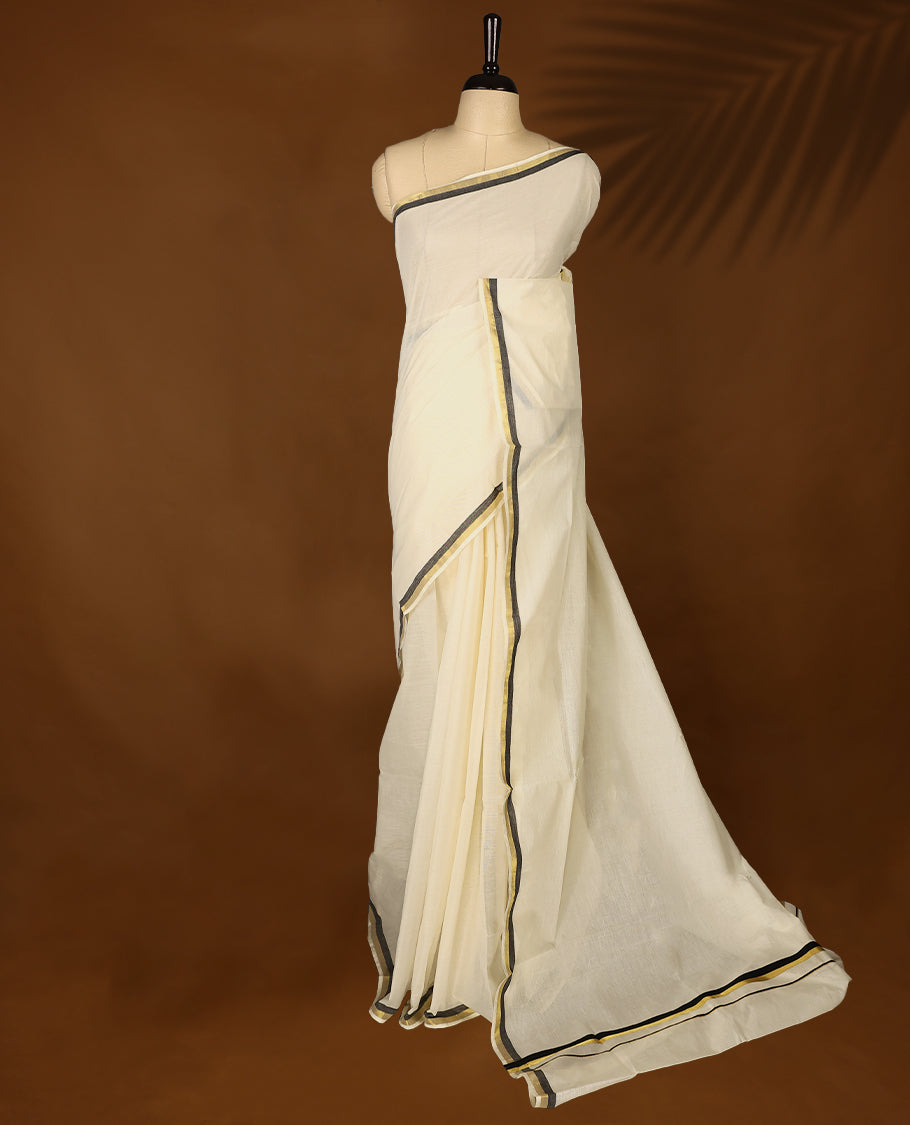 Elegant off white colour cotton Kerala saree featuring a plain body and traditional golden zari border with a hint of Pure Black, offering a classic and graceful look, paired with a matching blouse.
