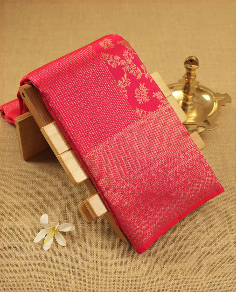 Rani pink colour Kanchipuram pattern Manthrakodi saree adorned with geometrical vertical lines with small diamond motifs and banarasi floral weaving on the body, edge to edge zari border and self jacquard blouse piece.