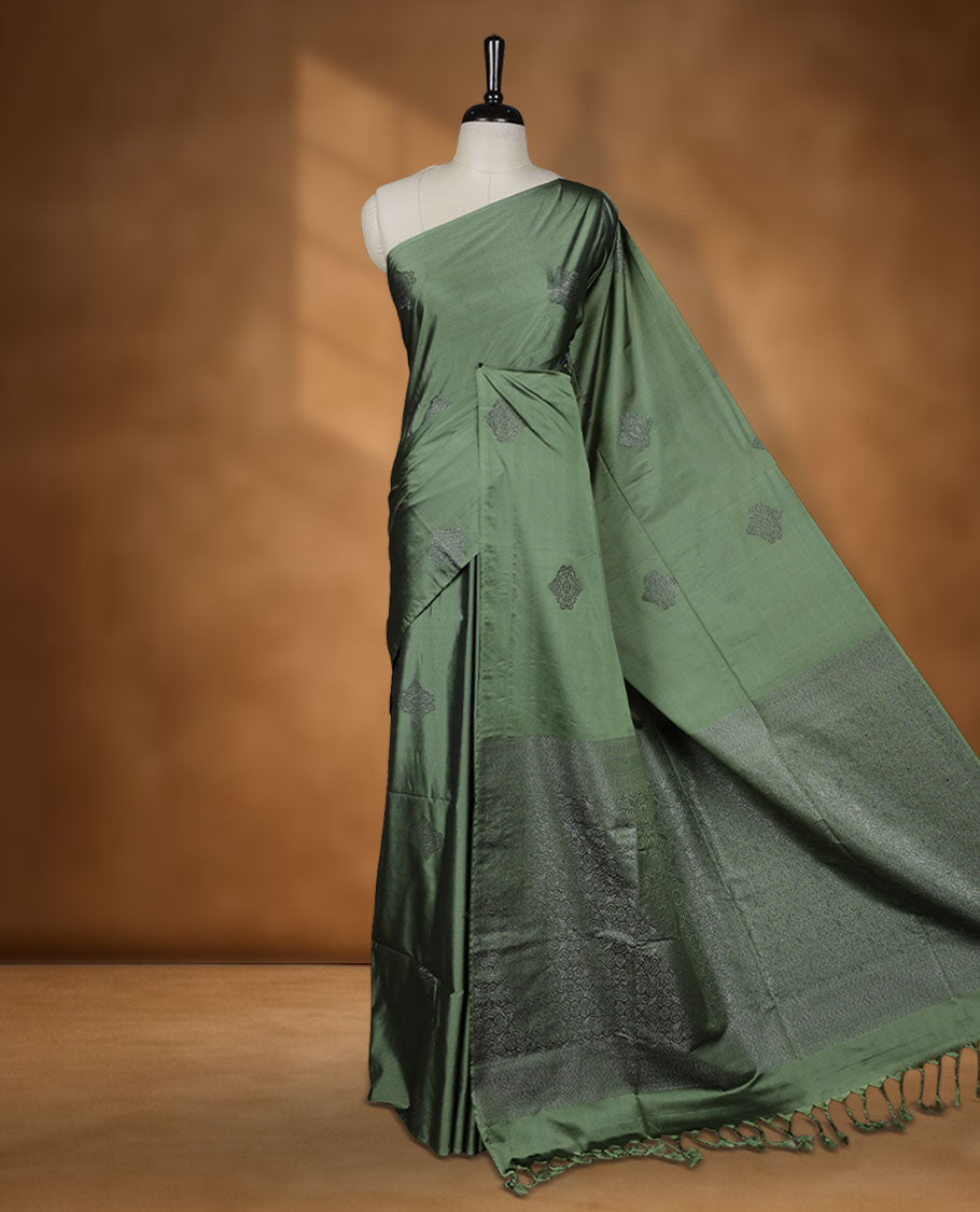 Maple green colour semi soft silk saree adorned with delicate woven motifs on the body, complemented by a Self colour woven pallu with intricate detailing and tassel accents without border & Comes with a matching blouse piece.