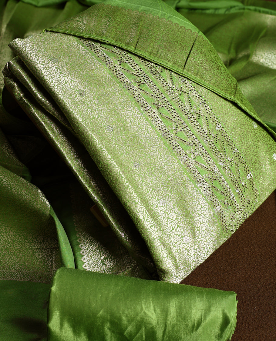 Light green colour churidhar material with elegant golden zari floral weaves and stone embellishments, paired with a plain matching bottom and dupatta.