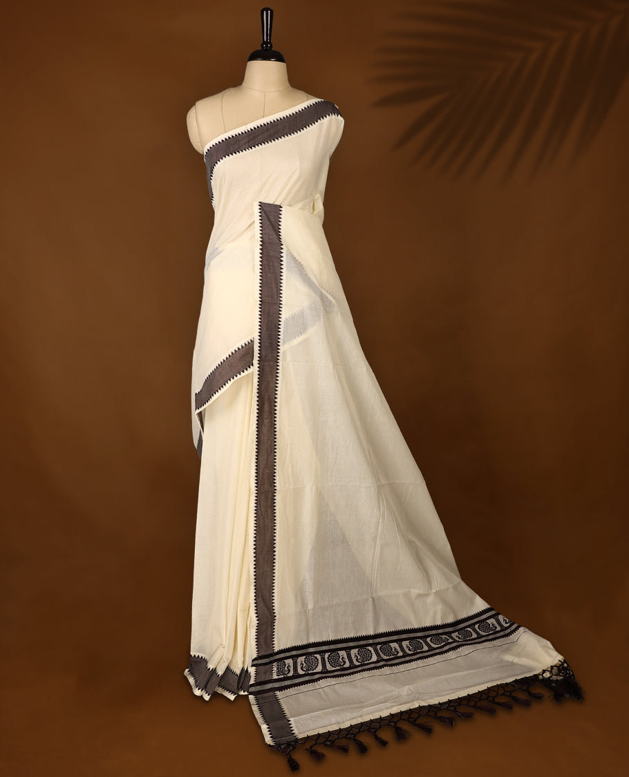 Elegant off white colour cotton Kerala saree featuring Plain body, Dark Chocolate colour border with Peacock Motifs, Paired with matching blouse offering a classic and graceful look, paired with a matching blouse.