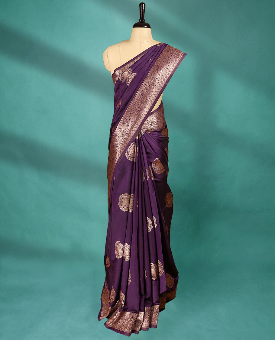 Royal Grape coloured semi silk saree featuring a Golden Zari design on the body, paired with a Self coloured border and matching blouse.