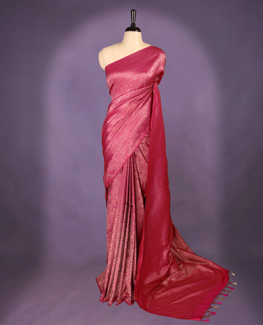 Magenta colour semi Banaras Katan saree featuring an antique Gold zari jacquard body, complemented by a self colour traditional border with a floral kodi design, paired with a matching blouse