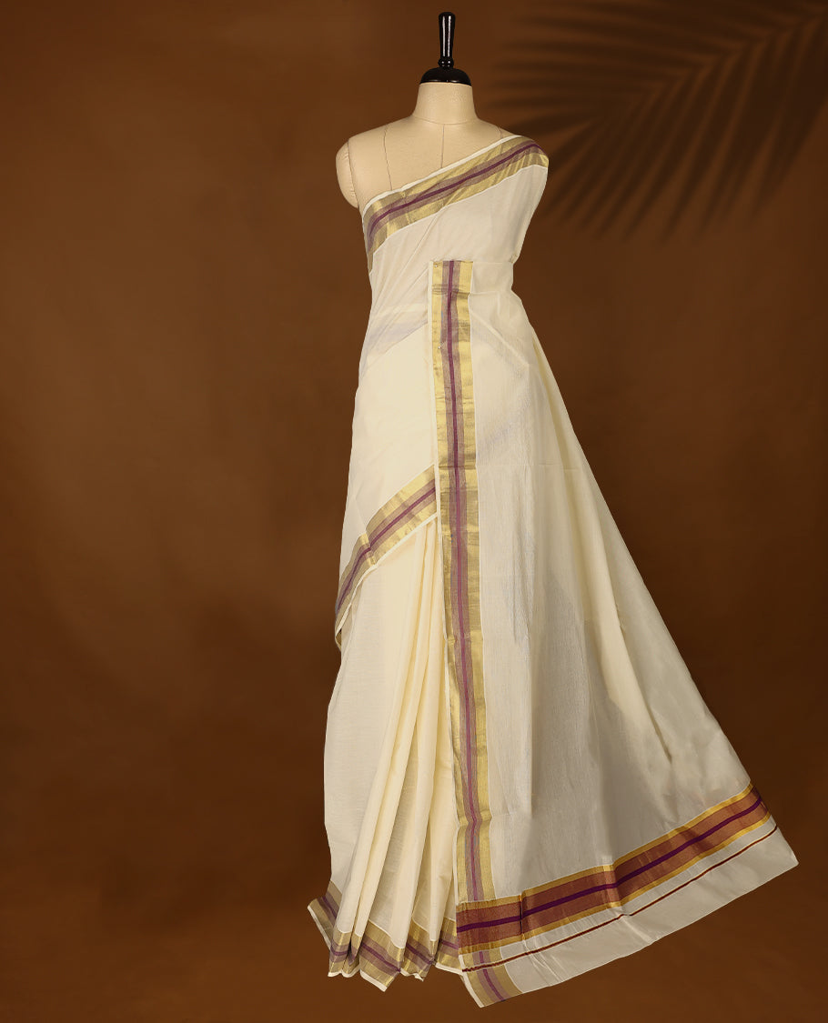 Elegant off white colour cotton Kerala saree featuring Plain body, Grape colour & golden zari kasavu border offering a classic and graceful look, paired with a matching blouse.