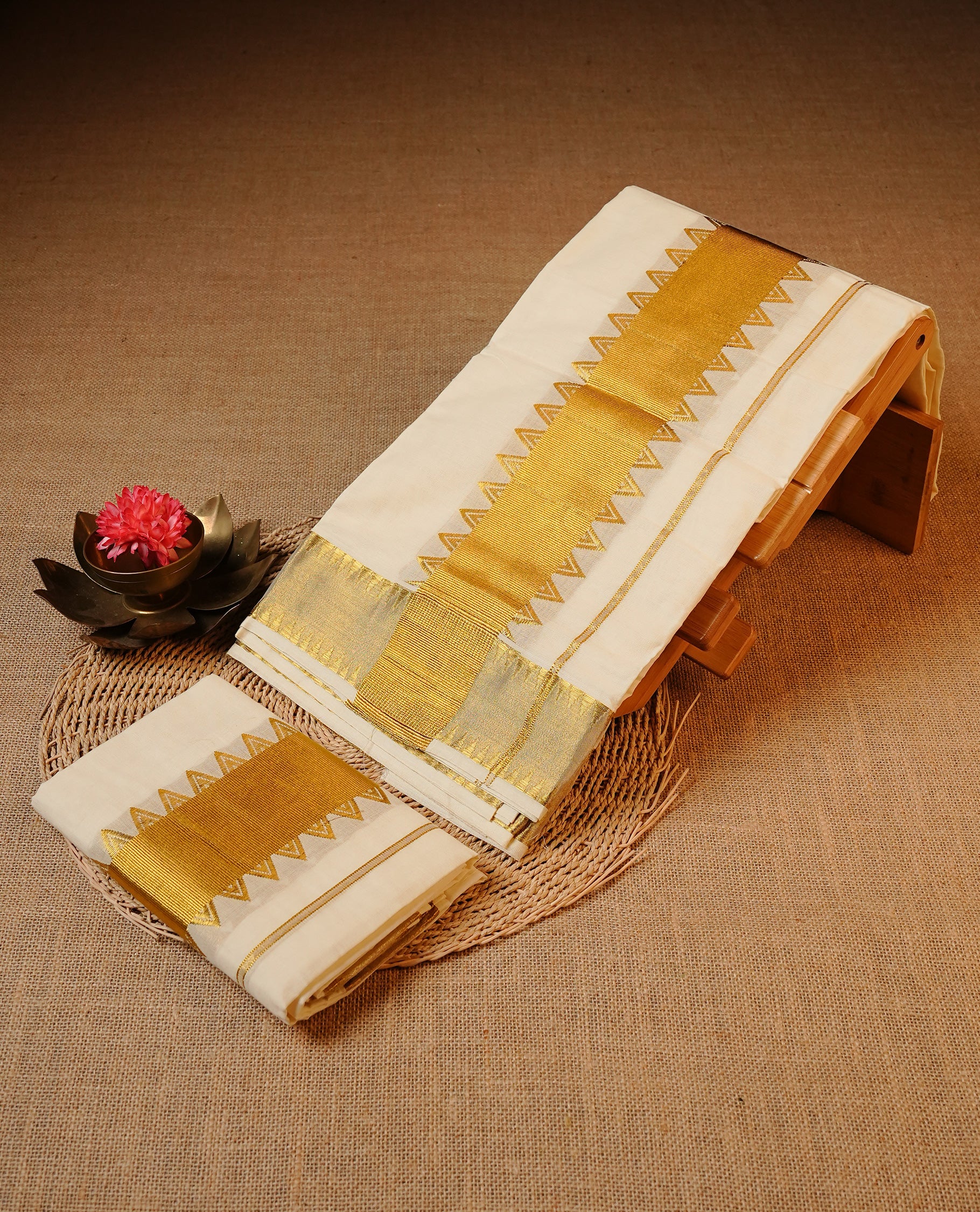 Off white colour Cotton Set Mund featuring a plain body, enhanced by a broad traditional gold zari kasavu border with temple pattern detailing.