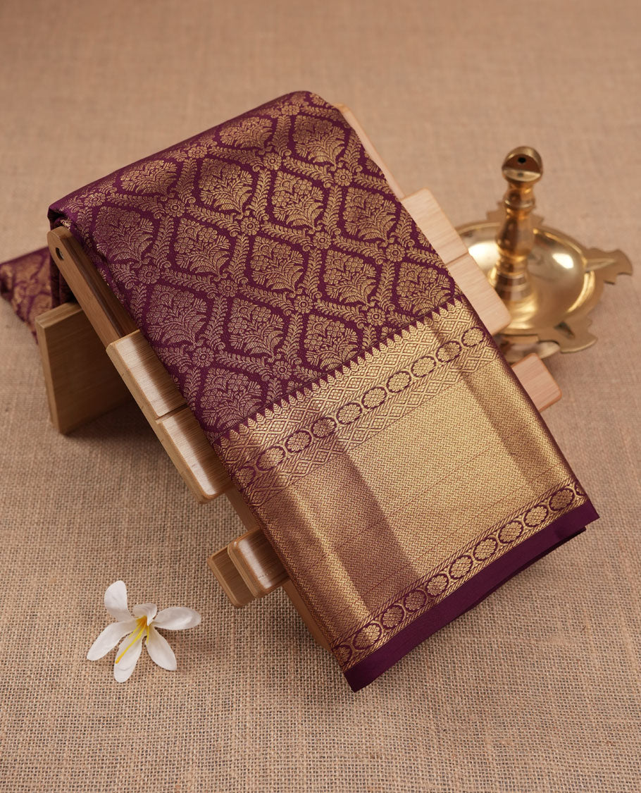 Dark burgundy colour Kanchipuram pattern Manthrakodi saree featuring metallic golden floral and leaf motif zari jaquard with kanchipuram traditional bavanji border and plain blouse piece with zari border.