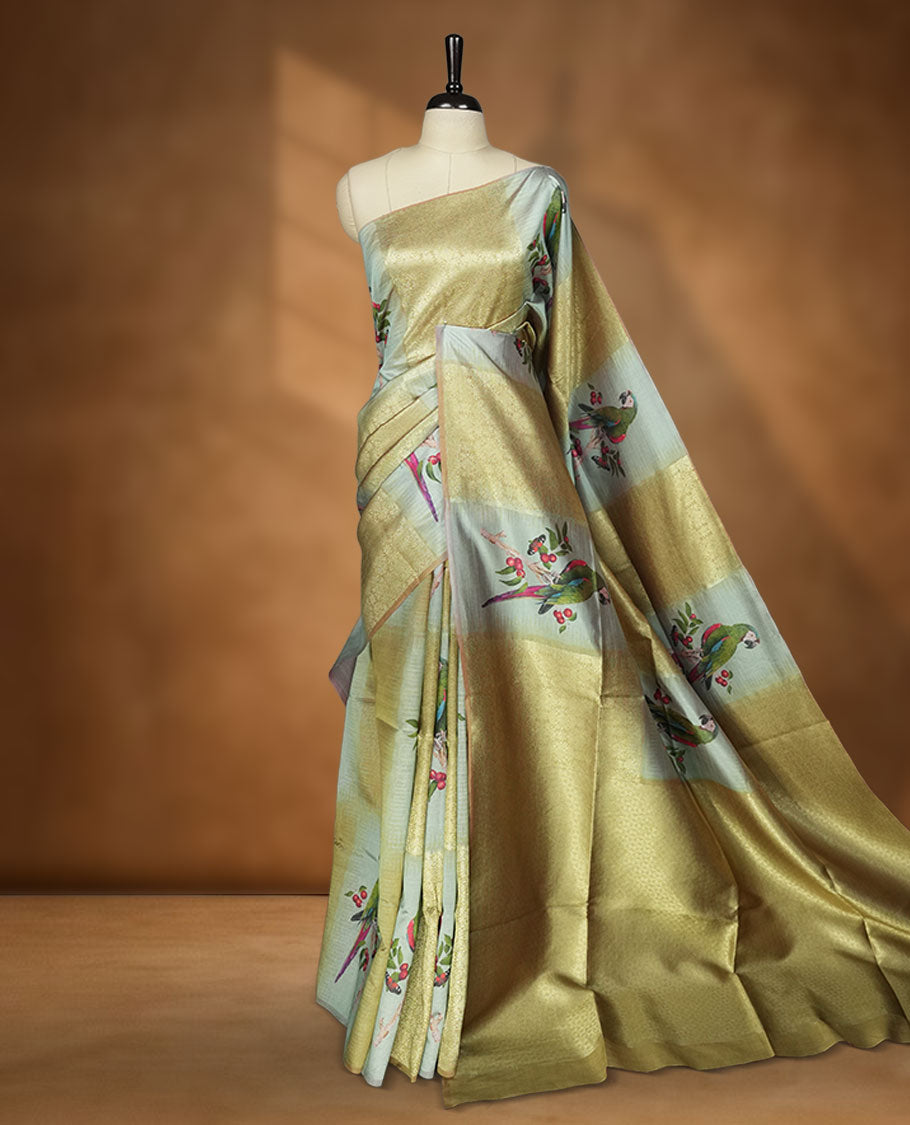 Parrot Green colour semi tussar Banarasi saree featuring vibrant multi-color floral prints across the body, with geometric zari patterns, and a matching blouse detailed with silver woven buttas.