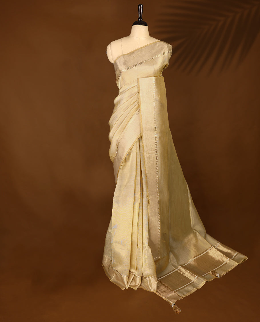 Elegant gold colour organza Kerala saree featuring a plain body, muted gold zari border, and a striking Gold Zari woven Bold pallu, paired with a matching blouse.