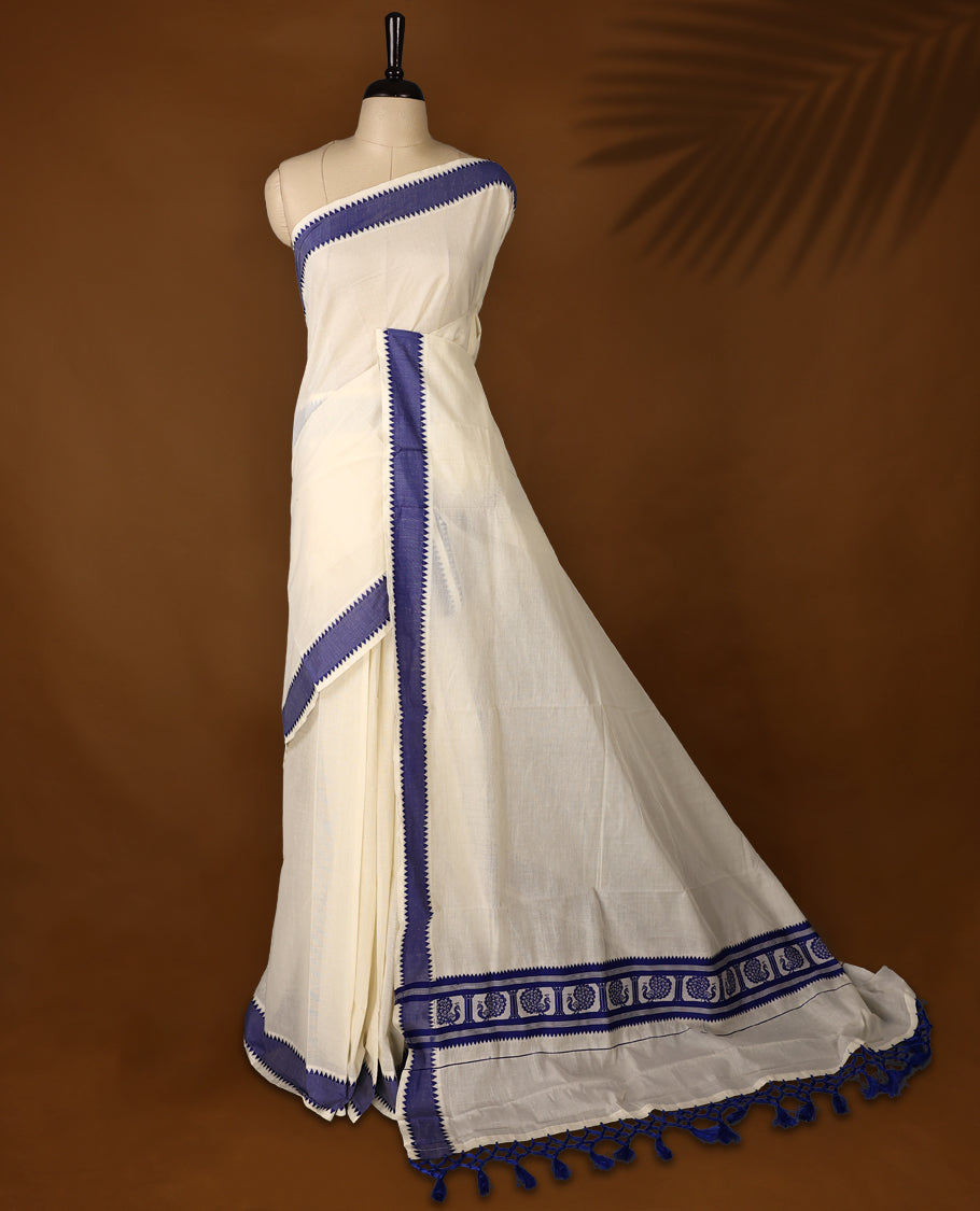 Elegant off white colour cotton Kerala saree featuring Plain body, Blue colour border with Peacock Motifs, Paired with matching blouse offering a classic and graceful look, paired with a matching blouse.