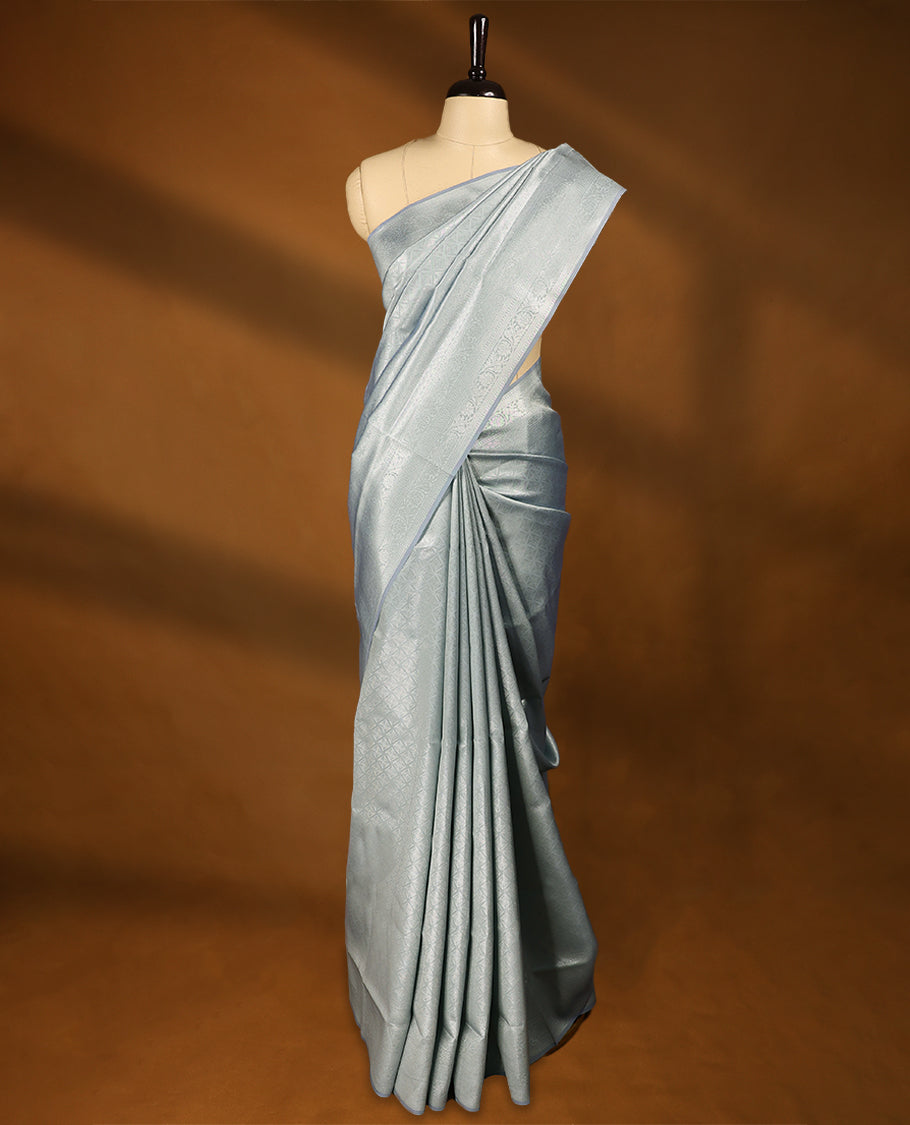 Pastel Grey coloured semi silk saree featuring a Silver coloured Zari Diamond design on the body, paired with a Self coloured border and matching blouse.
