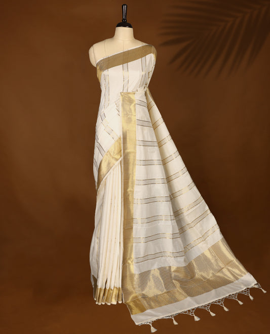 Elegant white colour sotf  Tussar Kerala saree featuring Bold Gold Zari stripes on body, Gold kasavu border, Rich Pallu, Paired with matching blouse offering a classic and graceful look