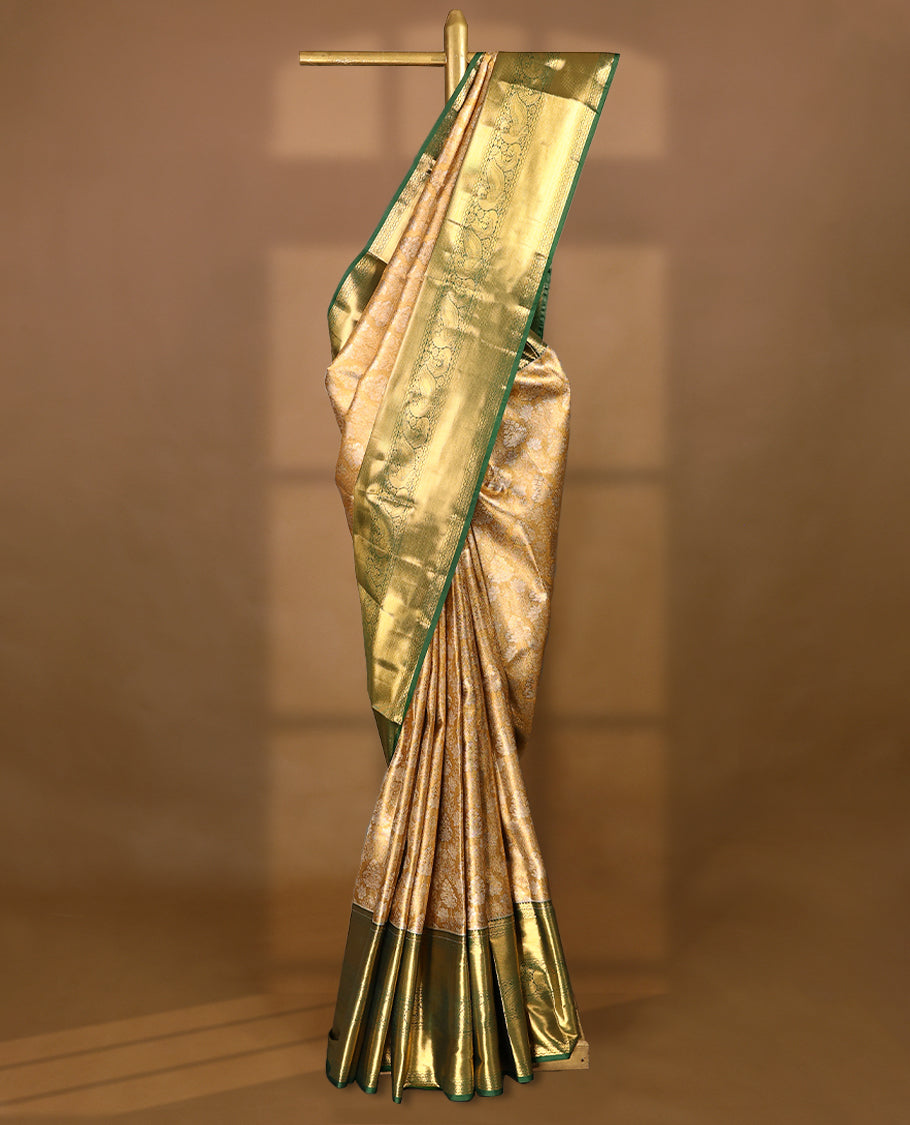 Gold colour tissue brocade saree with gold and silver zari lotus pattern on body, gold zari peacock and flower traditional green border, rich matching pallu with Antique zari motifs, paired with matching blouse.