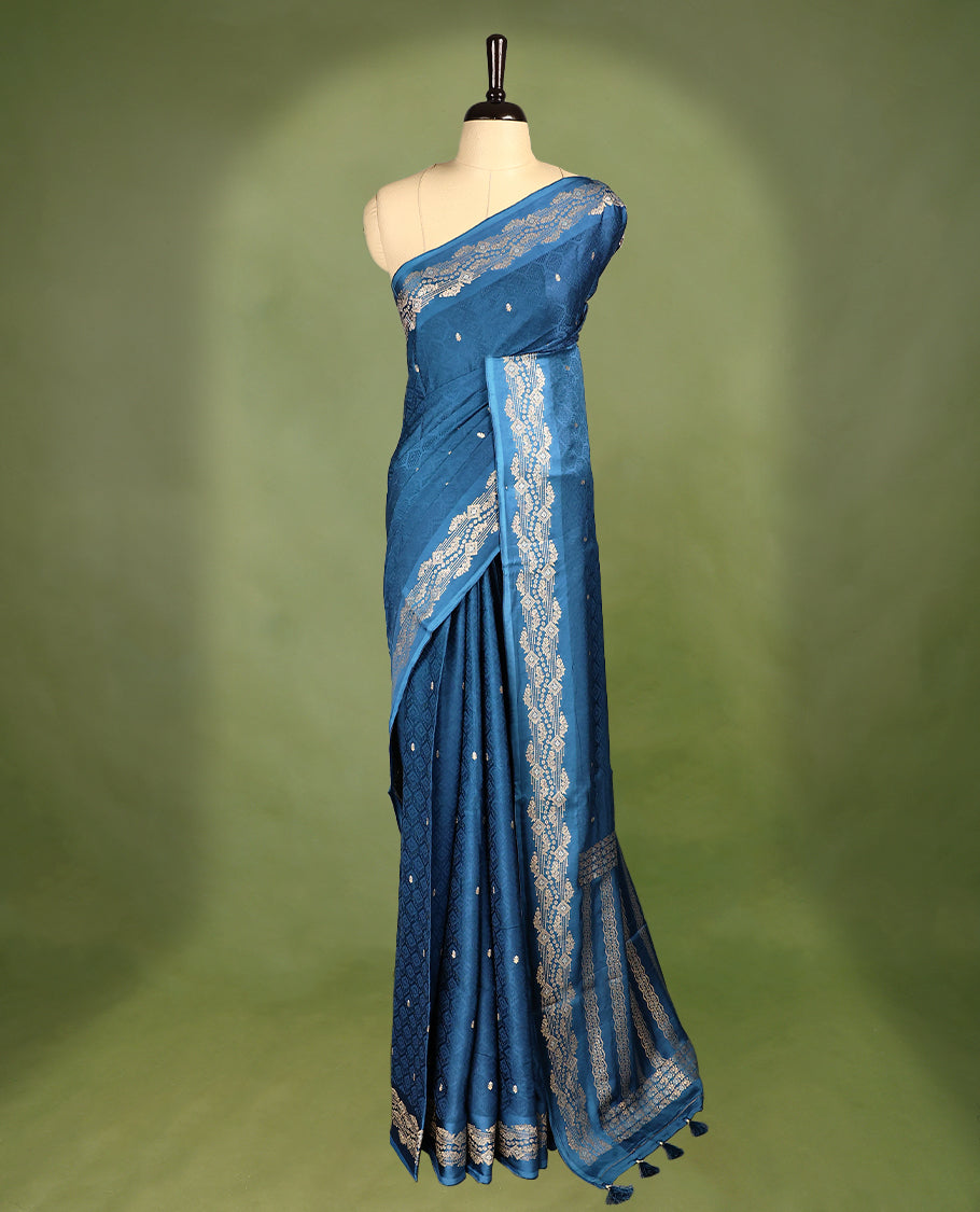 Peacock Blue colour pure Banaras crepe saree showcases elegant Gold & Silver zari Motifs all over the body, a traditional gold & Silver zari border, a rich intricately woven pallu, and comes with a matching blouse.