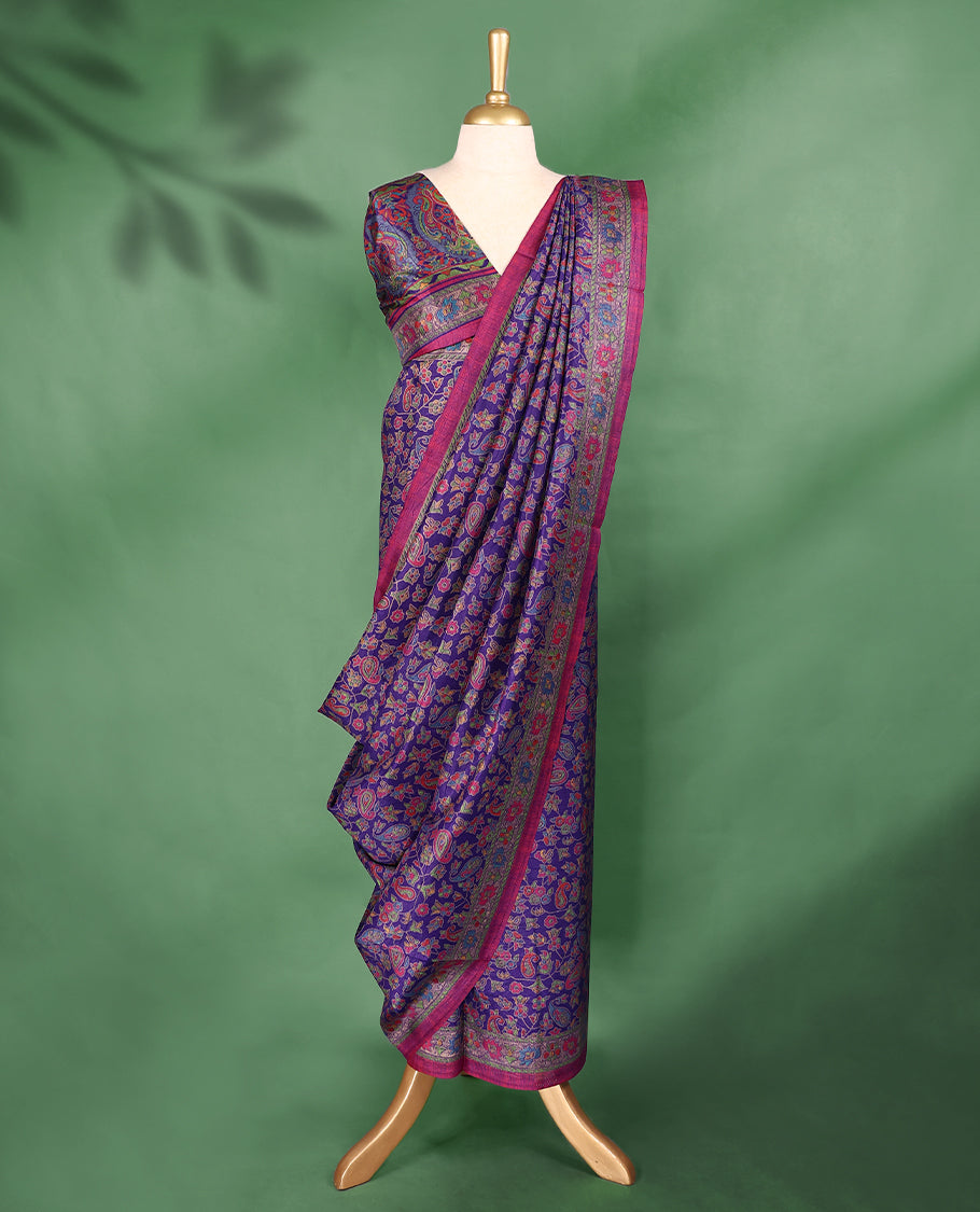 Purple Colour saree with multicolour floral and paisley motifs, detailed Contrast border, and a traditional design that comes with a matching blouse.