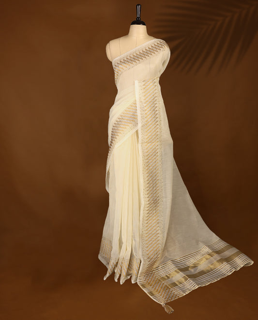 Ivory colour organza Kerala saree with golden zari detailing, featuring diagonal woven patterns on the pallu and border. Lightweight and elegant, it comes with a matching blouse piece for festive charm.