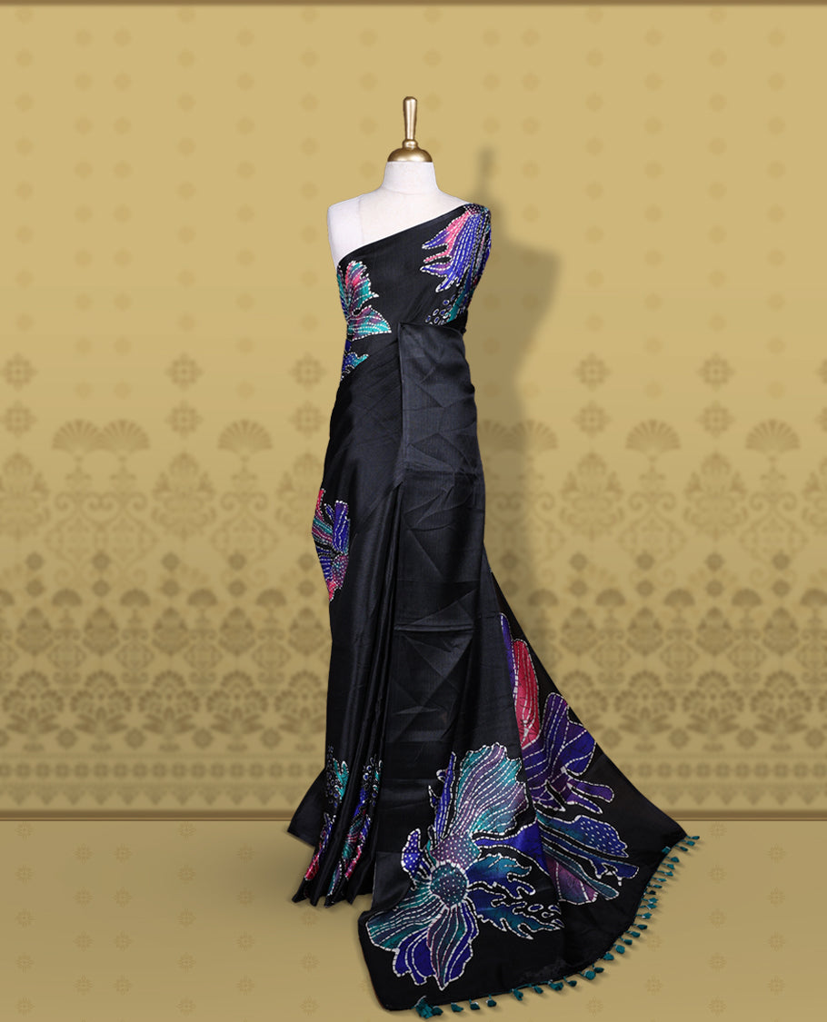 Black colour semi khadi silk saree adorned with navy blue,pink and aqua green colour bold floral motifs across the body, designed without a border for a contemporary touch, and paired with a matching blouse.