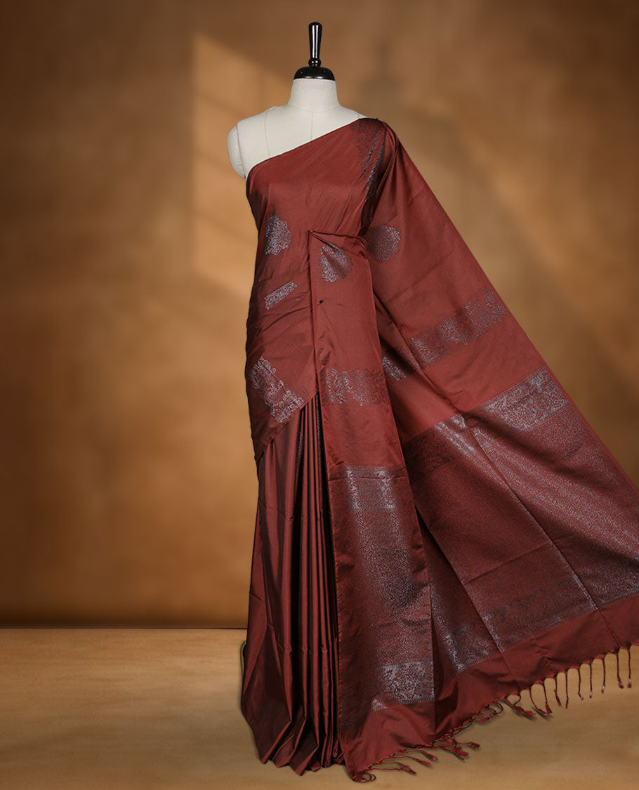 Deep red colour semi soft silk saree adorned with delicate woven floral kodi motifs on the body, complemented by a Self colour woven pallu with intricate detailing and tassel accents without border & Comes with a matching blouse piece.