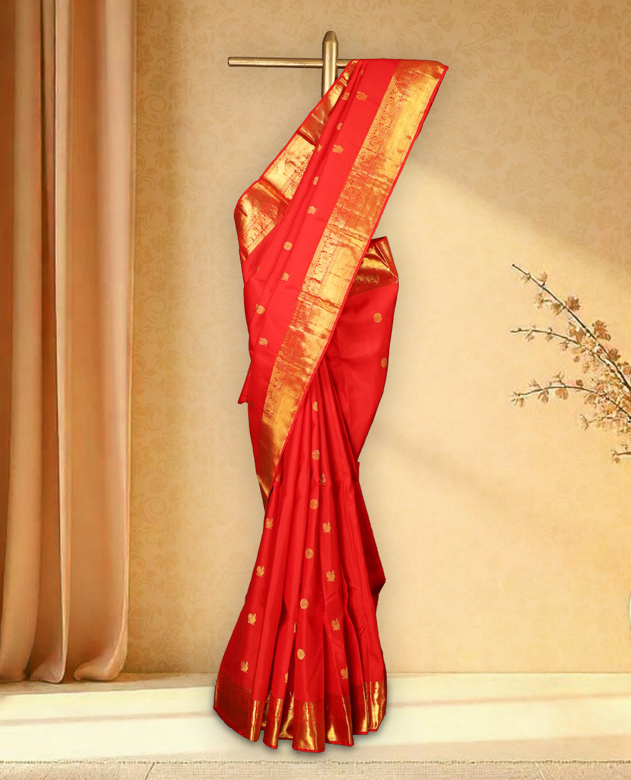 Chilly red colour pure Kancheepuram saree with gold zari Mayoora Chakra motifs on the body, traditional border with peacock and diagonal line patterns, grand pallu with Chathurakamalam and Thilakam, paired with matching blouse.