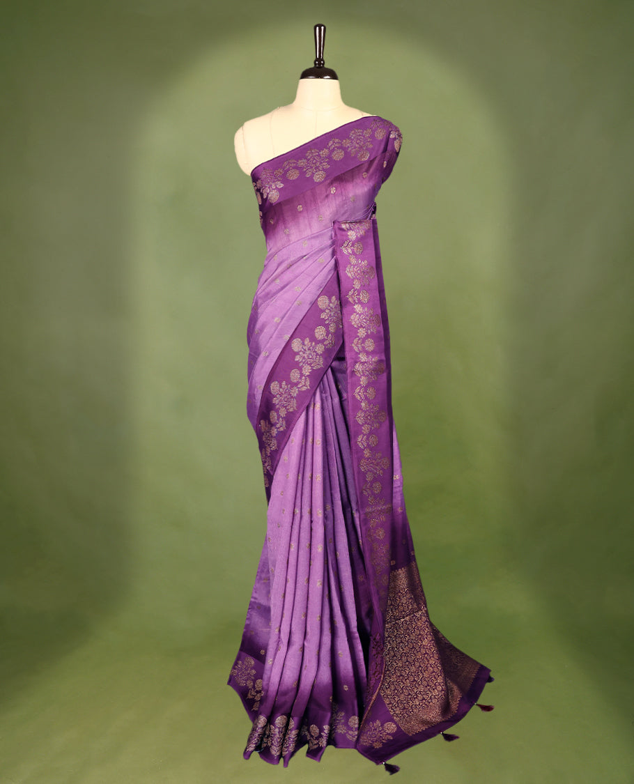Lavender and purple double shade semi Banaras Tussar Georgette saree adorned with elegant antique gold zari floral motifs across the body, featuring a detailed woven border and grand pallu, paired with a matching blouse piece.