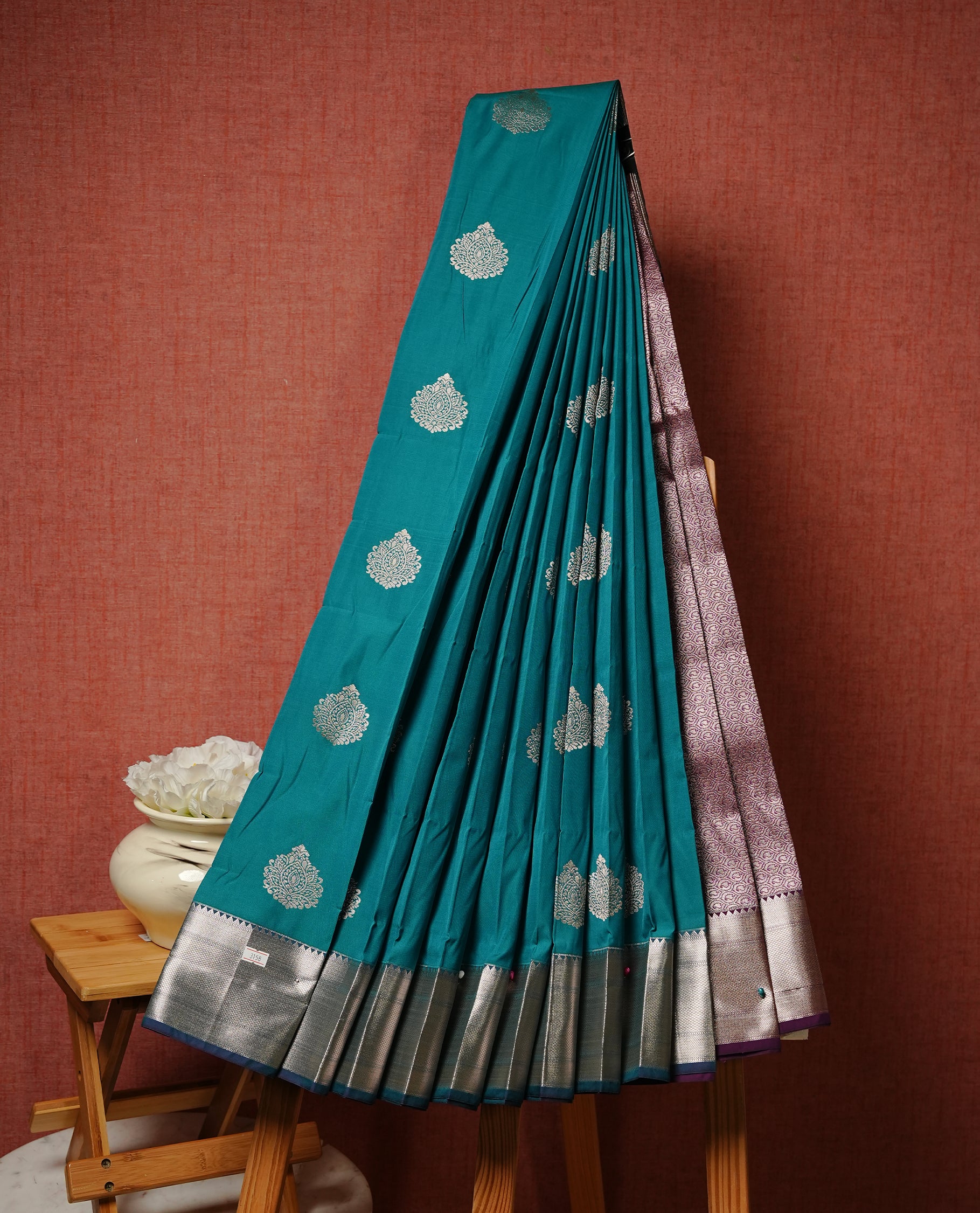 Green colour Semi silk saree Featuring gold zari motifs on body, complemented by contrast Teal colour with gold zari border, paired with matching blouse piece.