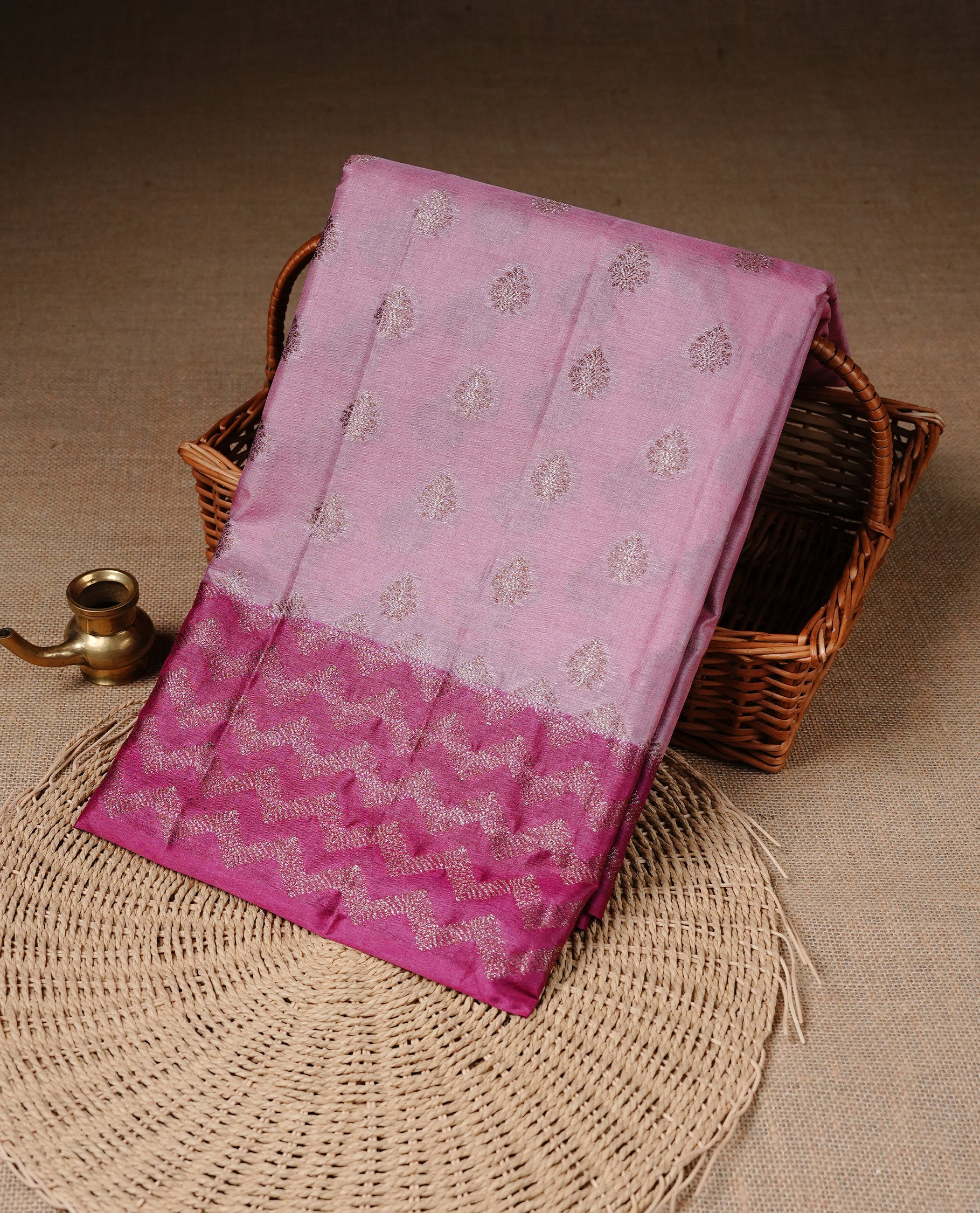 Pink Colour Tussar silk saree featuring Antique Zari motifs on body, Finished with contrast Magenta colour Zigzag zari pattern border, paired with matching blouse piece.
