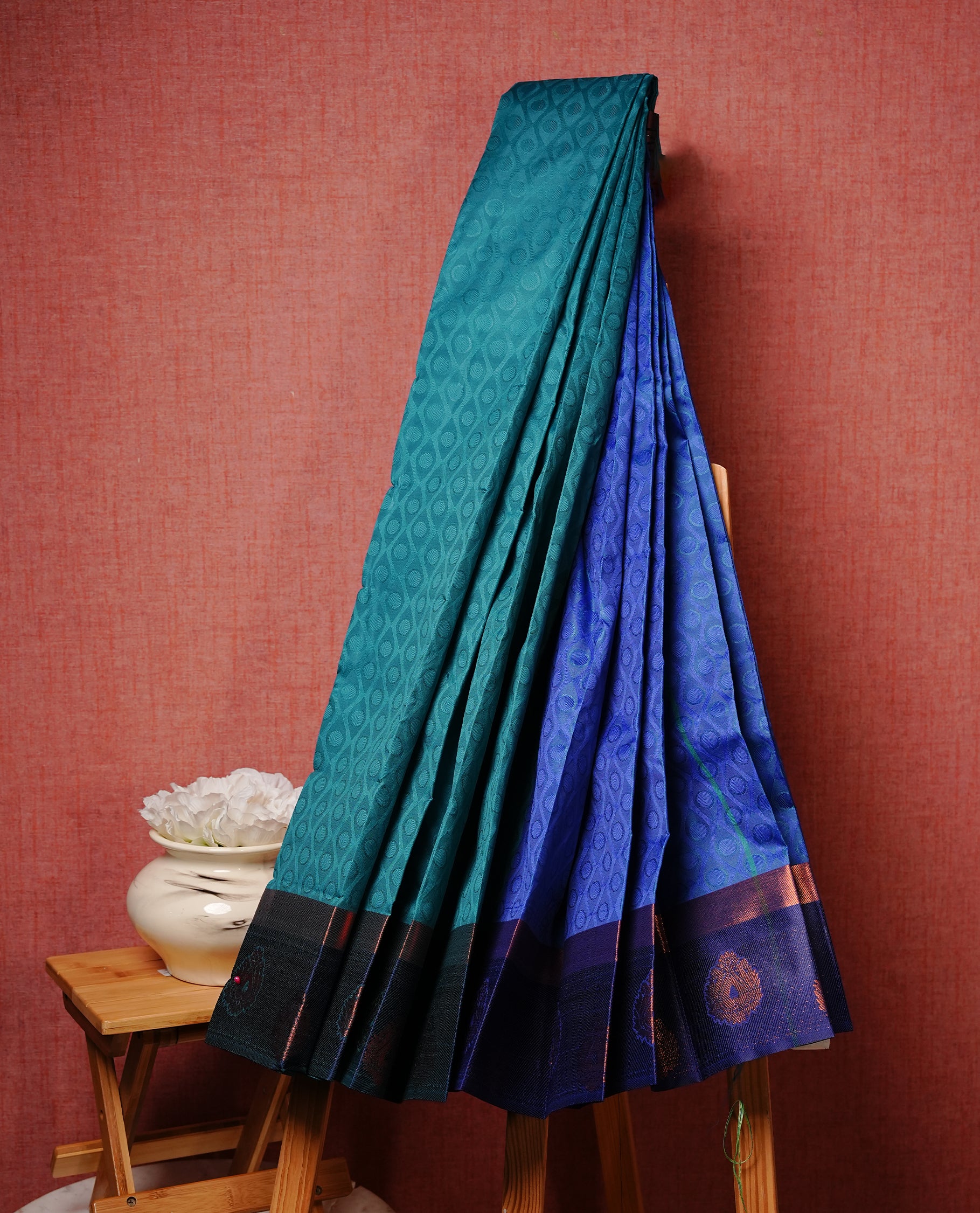 Teal green colour Semi silk saree Featuring self colour zari pattern on body, complemented by contrast Blue colour with gold zari border, paired with matching blouse piece.