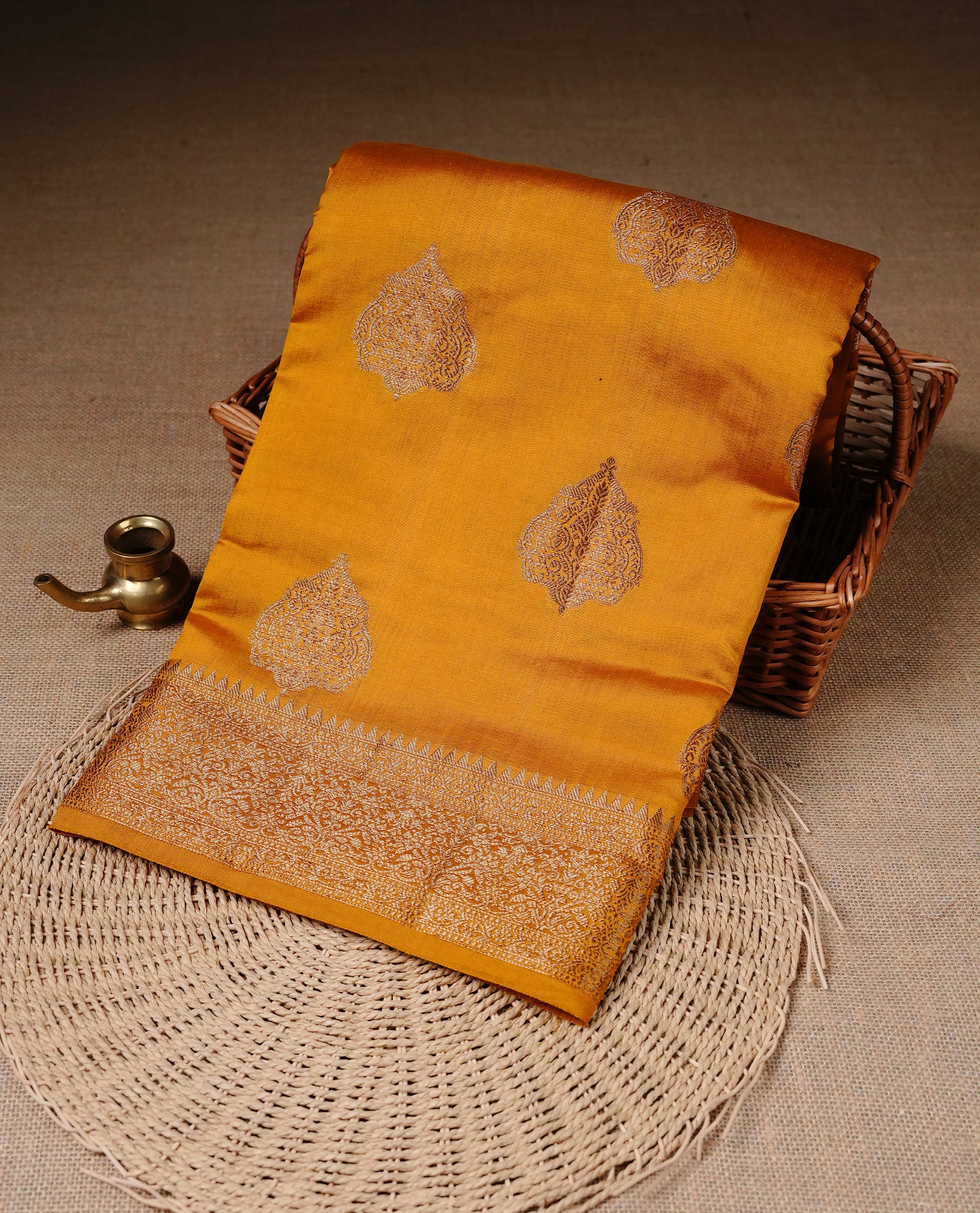 Mustard Colour Pure Banaras Soft Silk saree featuring Antique Zari buttas in body, complemented by zari work on self colour border, paired with matching Blouse Piece.