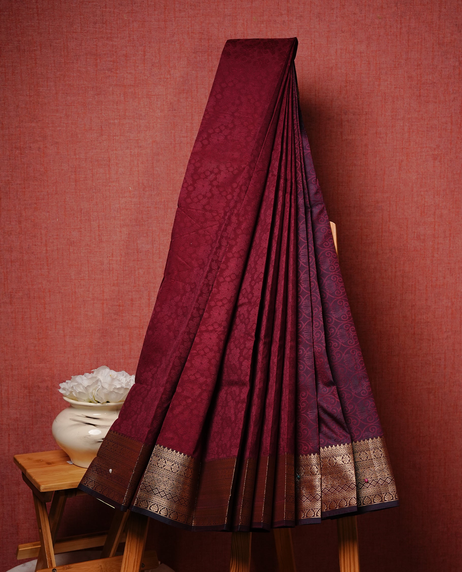Maroon colour Semi silk saree Featuring selfcolour zari motifs on body, complemented by contrast Green colour with gold zari border, paired with matching blouse piece.
