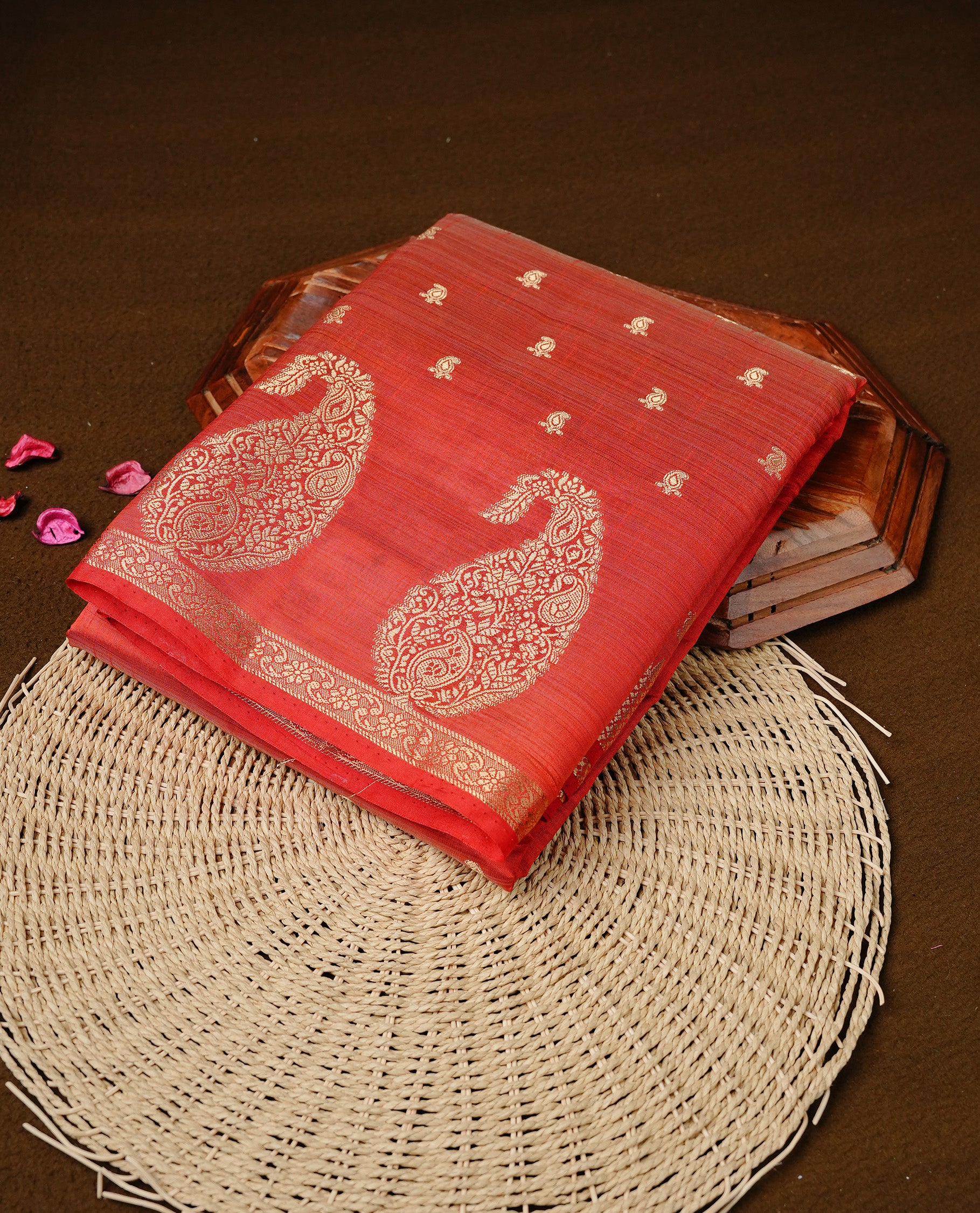 Red colour semi tussar silk saree featuring small gold zari mango motifs across the body, enhanced with a self colour border showcasing elegant gold zari mango patterns. Paired with a matching blouse piece.