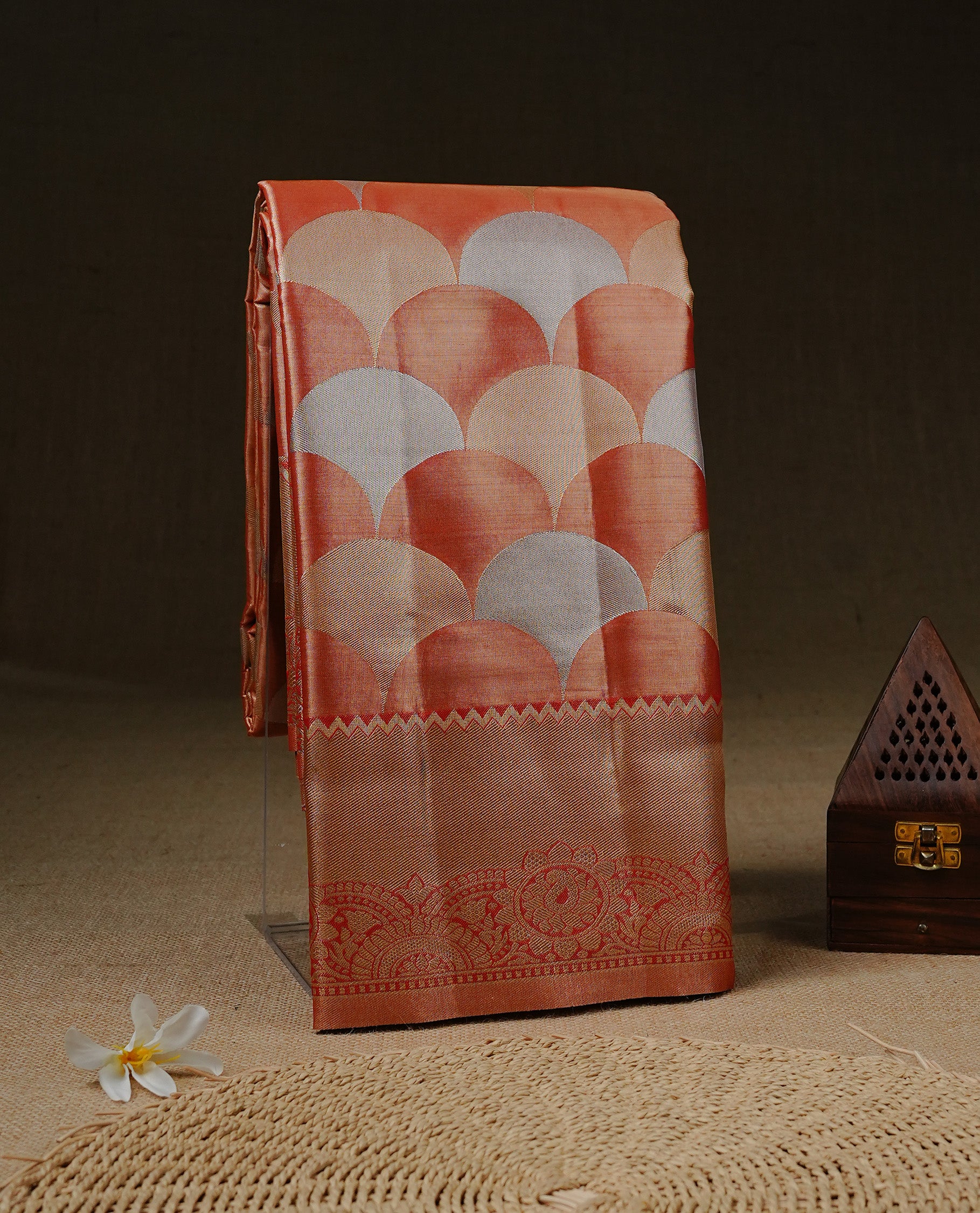 Light orange colour Tissue saree Featuring orange, Gold, silver zari Scales design on body, complemented by traditional border on self colour, paired with matching blouse piece.