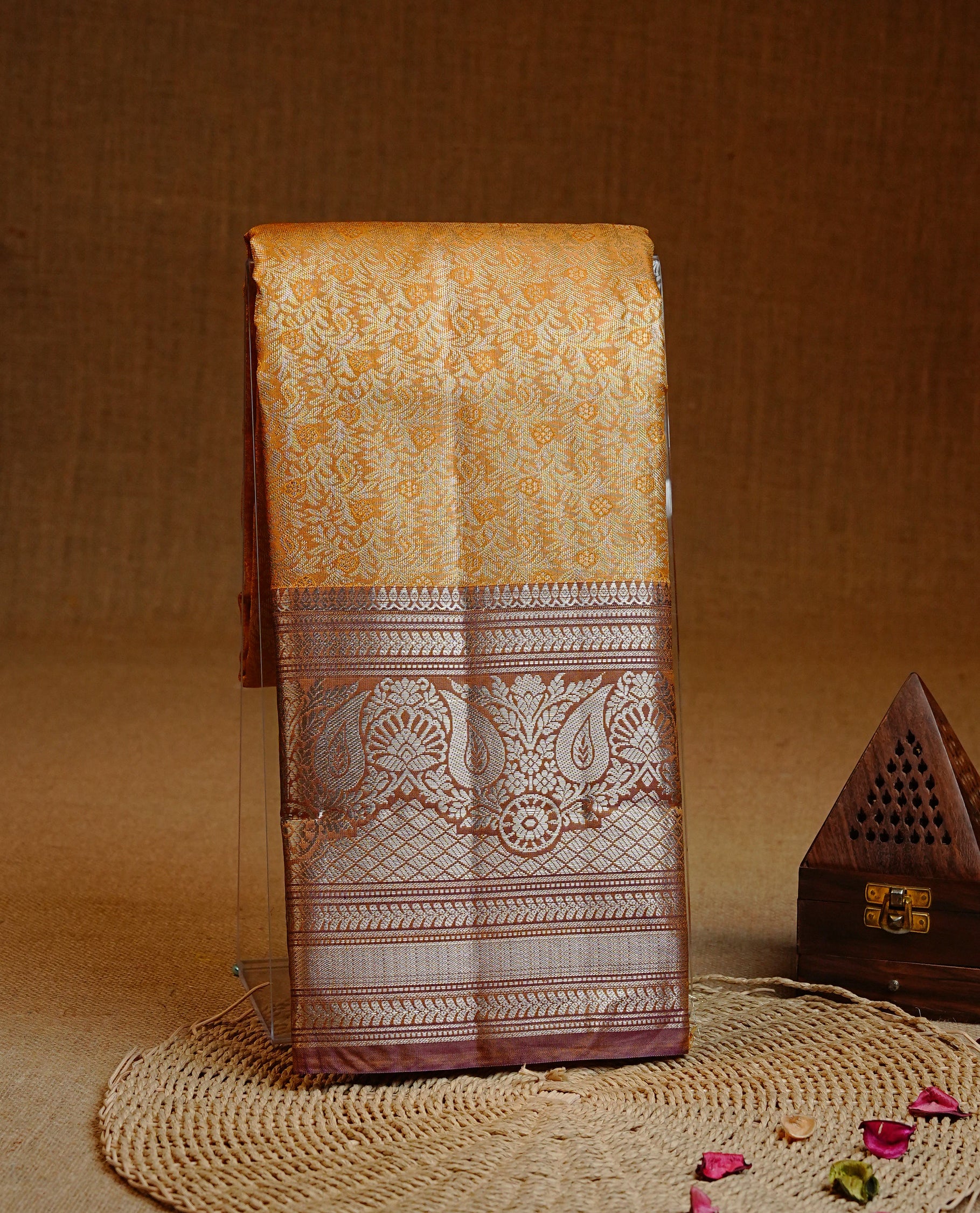 Yellow colour Semi tissue silk saree featuring Light gold zari kodi floral motifs on body, Contrast Brown colour with traditional border, paired with matching blouse piece.