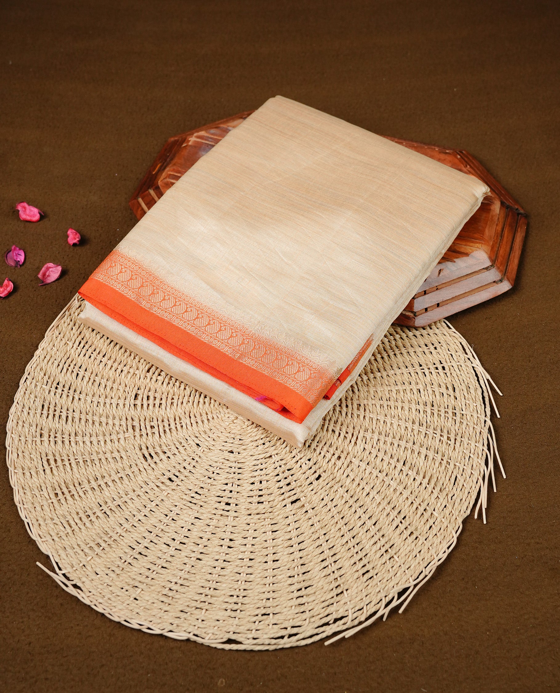Cream colour Semi Tussar silk saree featuring an elegant plain body, accentuated by a contrast Orange border adorned with intricate gold Mango zari work, paired with a matching blouse piece.