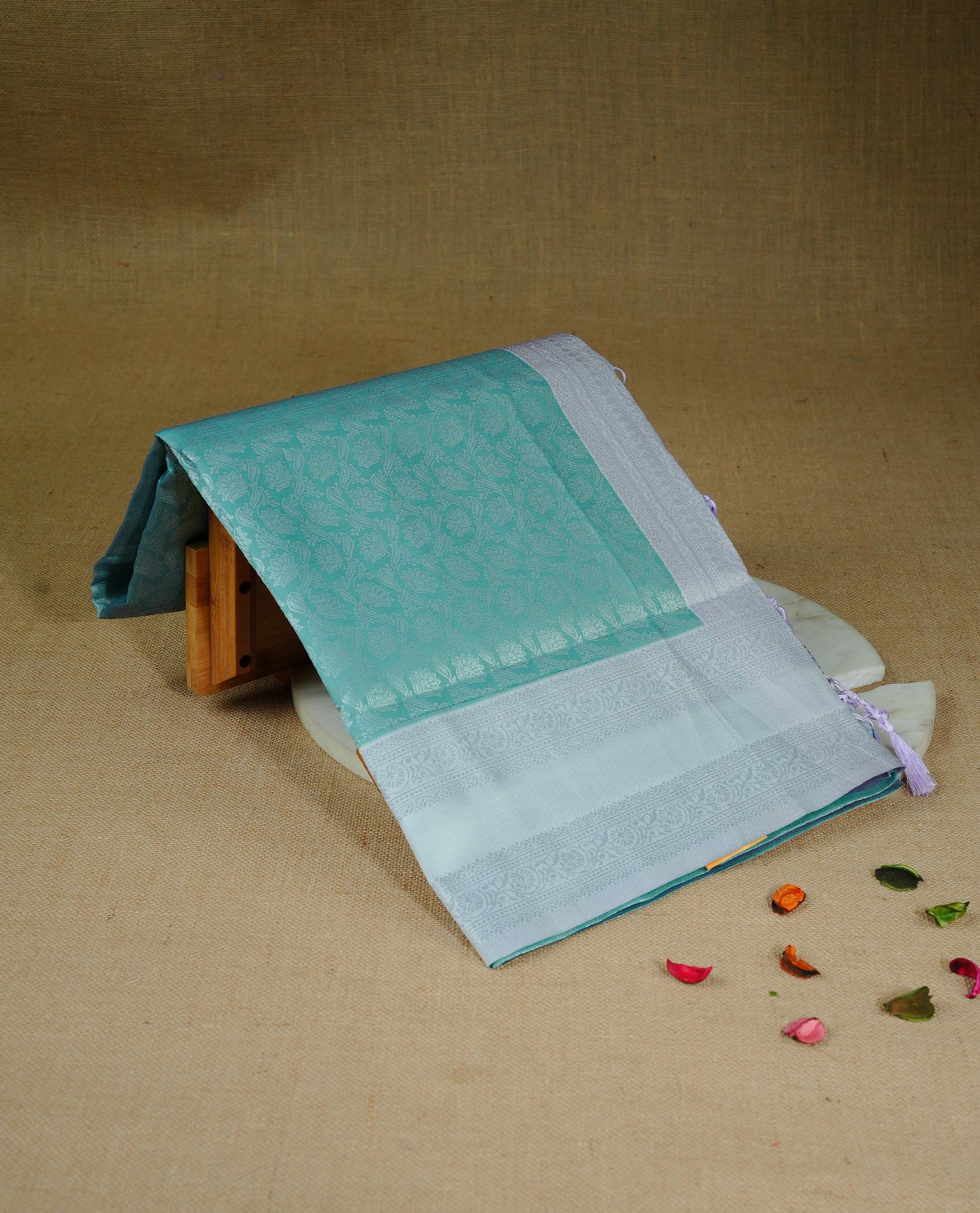 Pastel green colour semi silk saree featuring Silver zari Floral pattern on body, complemented by contrast Lavender colour with silver zari border, comes with matching blouse piece.