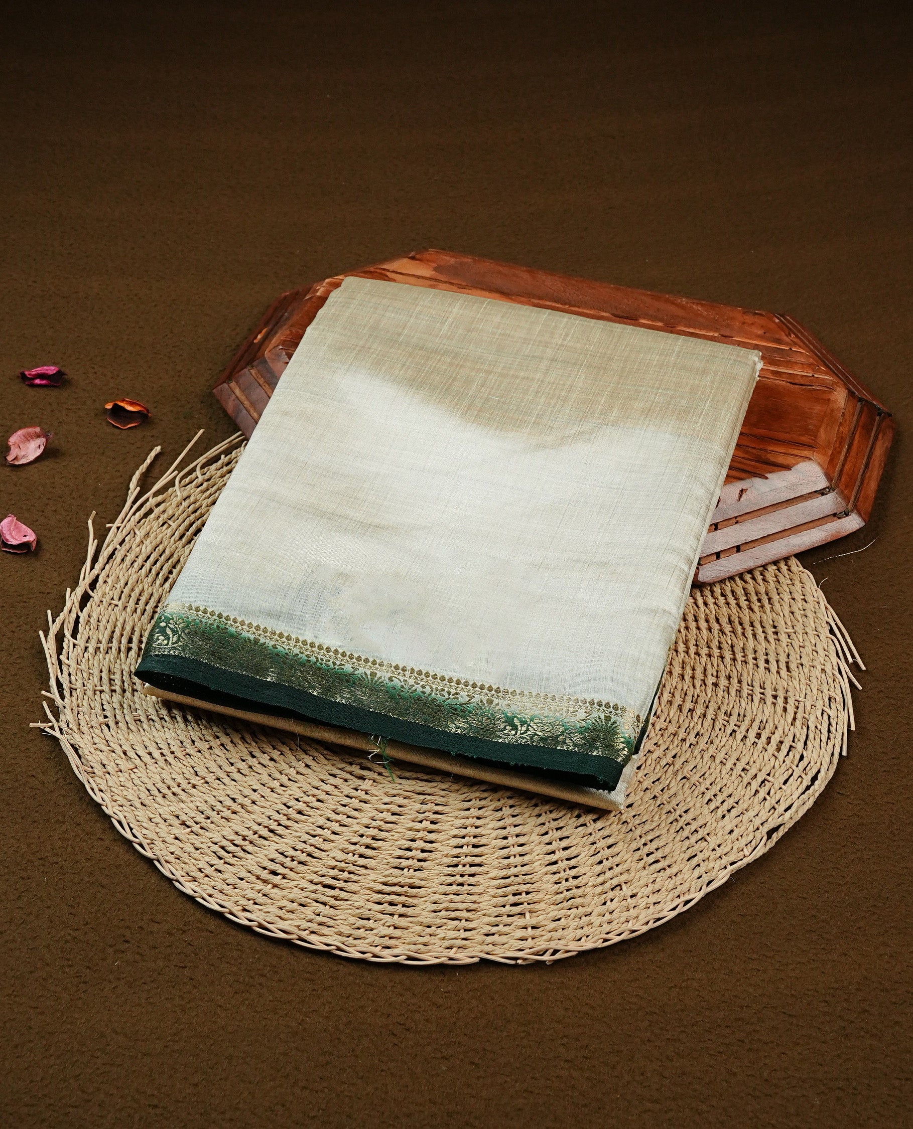 Light gold Colour Tussar saree featuring elegant plain body, complemented by contrast Dark green colour with zari work border, comes with matching blouse piece.