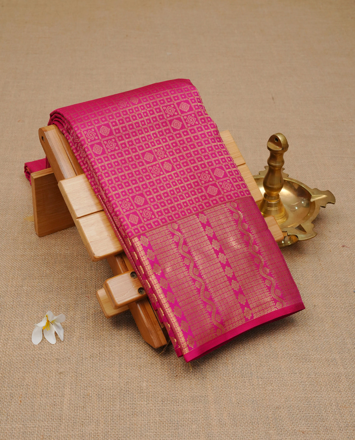 Magenta colour Pure wedding silk saree featuring gold zari check with small buttas on body, complemented vy self colour with traditional border, comes with matching blouse piece.