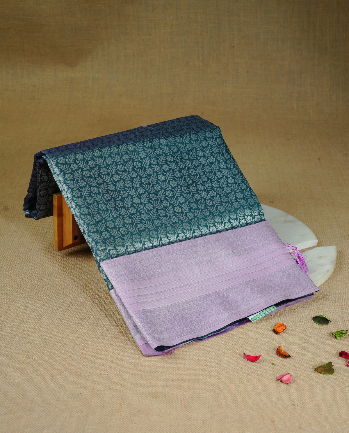 Green colour semi silk saree featuring Silver zari Floral pattern on body, complemented by contrast Purple colour with silver zari border, comes with matching blouse piece.