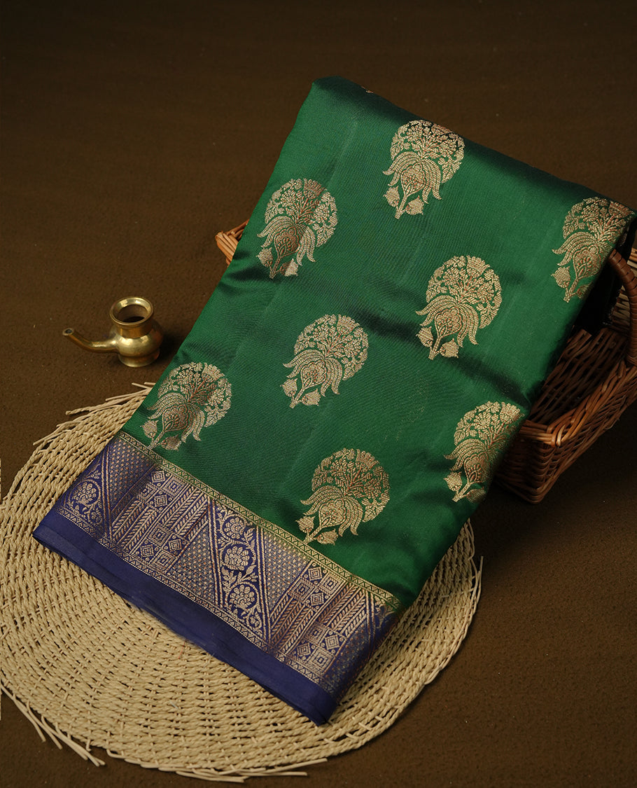 Dark green colour Pure tussar Banarasi saree featuring Gold zari motifs on body, a contrast navy blue colour gold zari border, and a matching blouse piece.