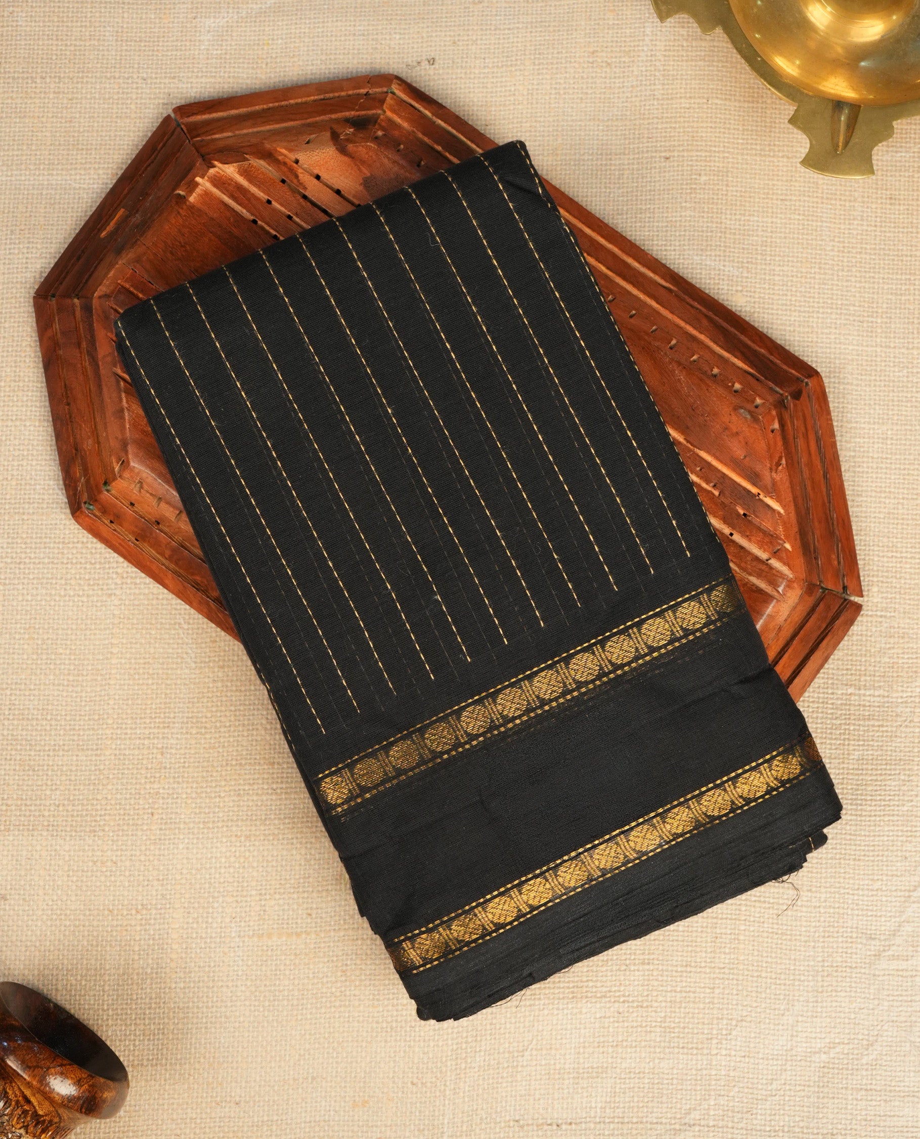 Black Colour Mangalagiri cotton saree with a Gold Zari Striped body, contrast Gold Zari striped border & pallu . Paired with a matching blouse piece .