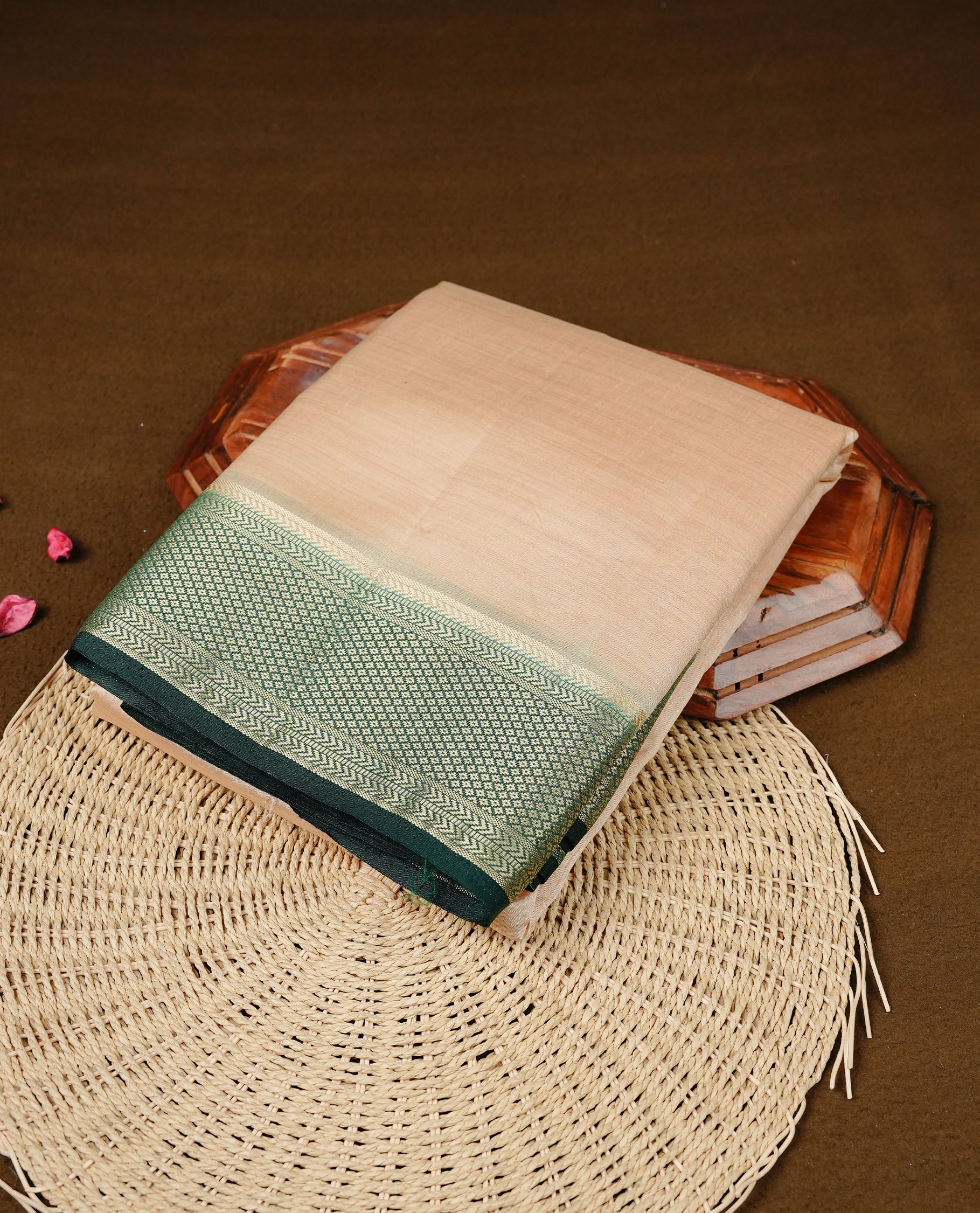 Cream colour Semi Tussar silk saree featuring an elegant plain body, accentuated by a contrast Green border adorned with intricate gold zari work, paired with a matching blouse piece.