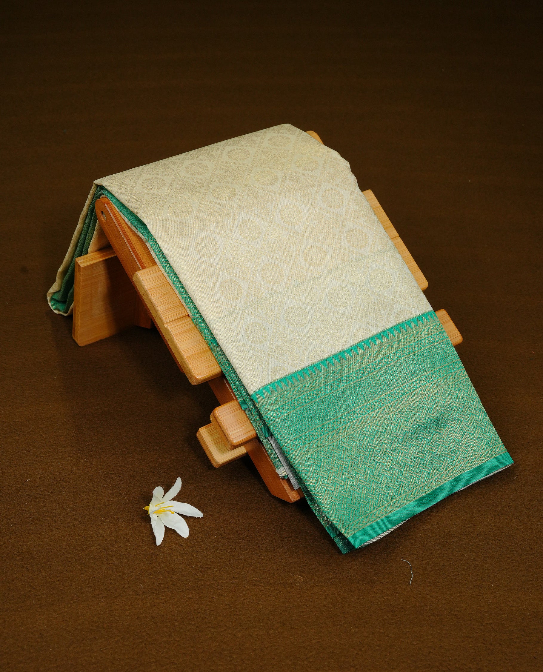 Cream Colour Semi Soft Silk Saree Featuring Gold zari Box With motifs Pattern On Body, Highlighted by contrast Green border with Gold zari, paired with matching blouse piece.