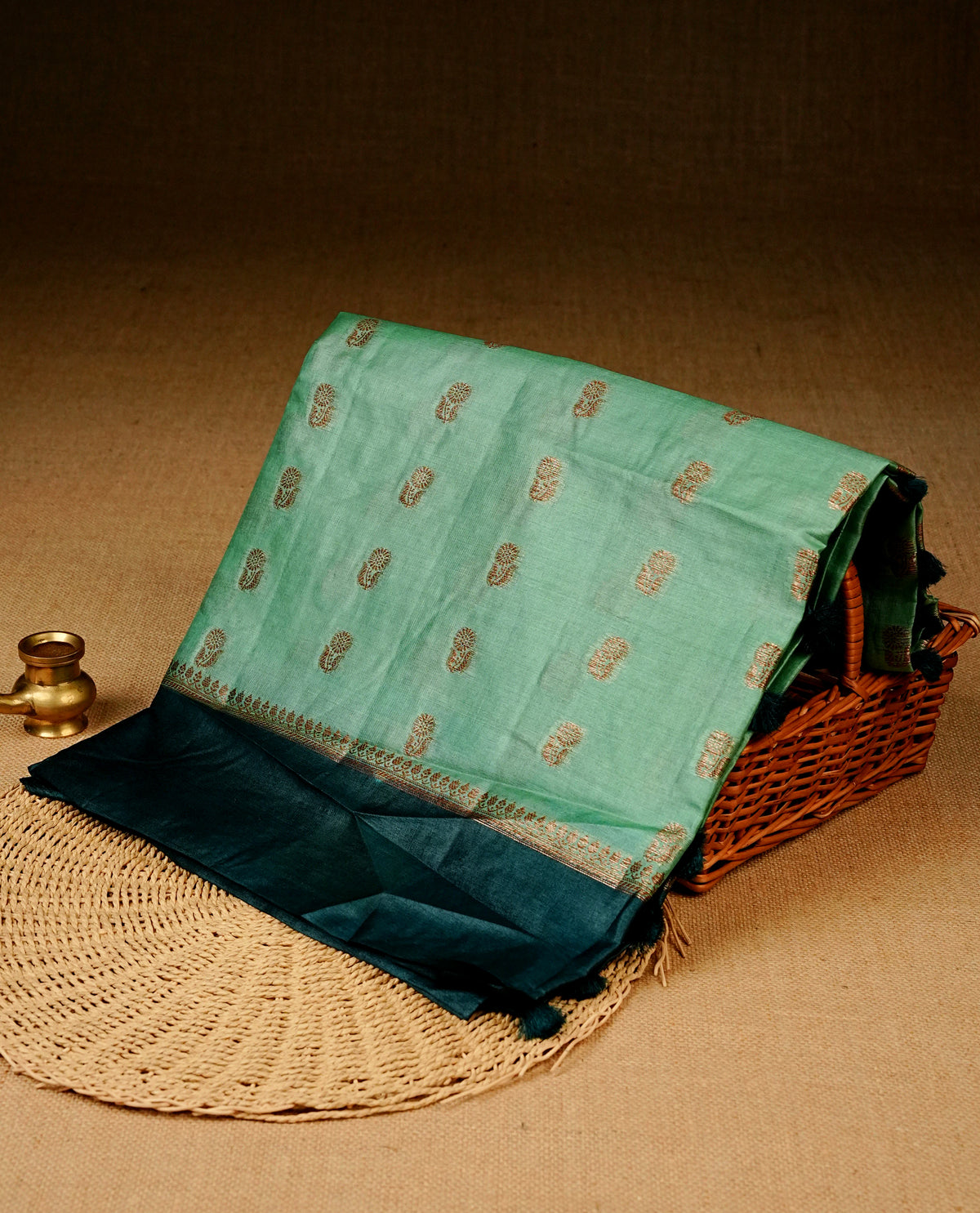 Light Aqua colour banaras silk saree featuring Gold zari buttas on body, complemented by contrast teal colour border, comes with matching blouse piece.