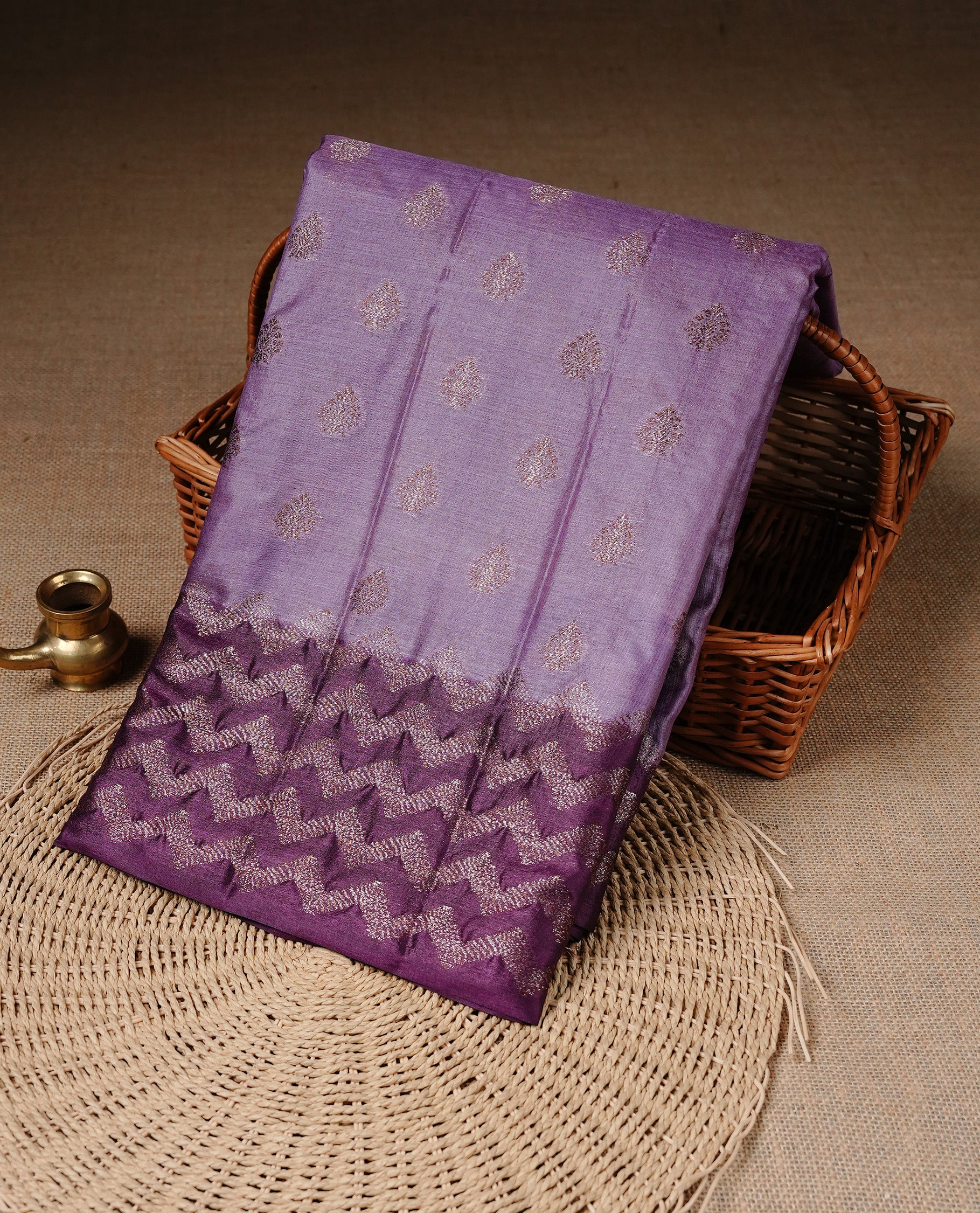Pastel purple Colour Tussar silk saree featuring Antique Zari motifs on body, Finished with contrast Purple colour Zigzag zari pattern border, paired with matching blouse piece.