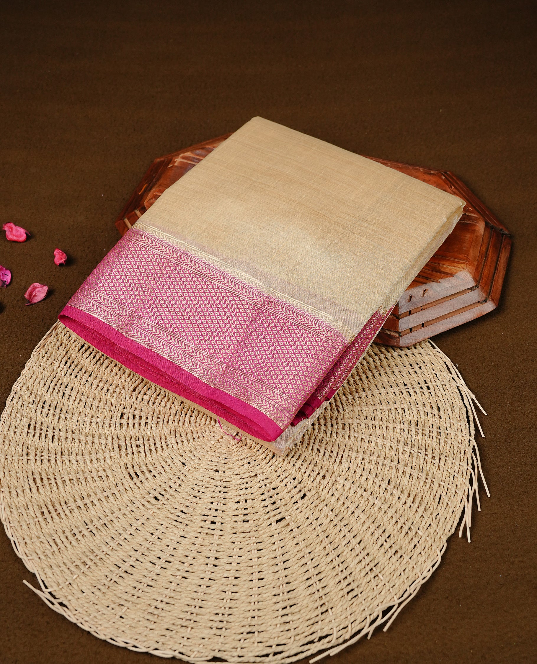 Cream colour Semi Tussar silk saree featuring an elegant plain body, accentuated by a contrast Dark pink border adorned with intricate gold zari work, paired with a matching blouse piece.
