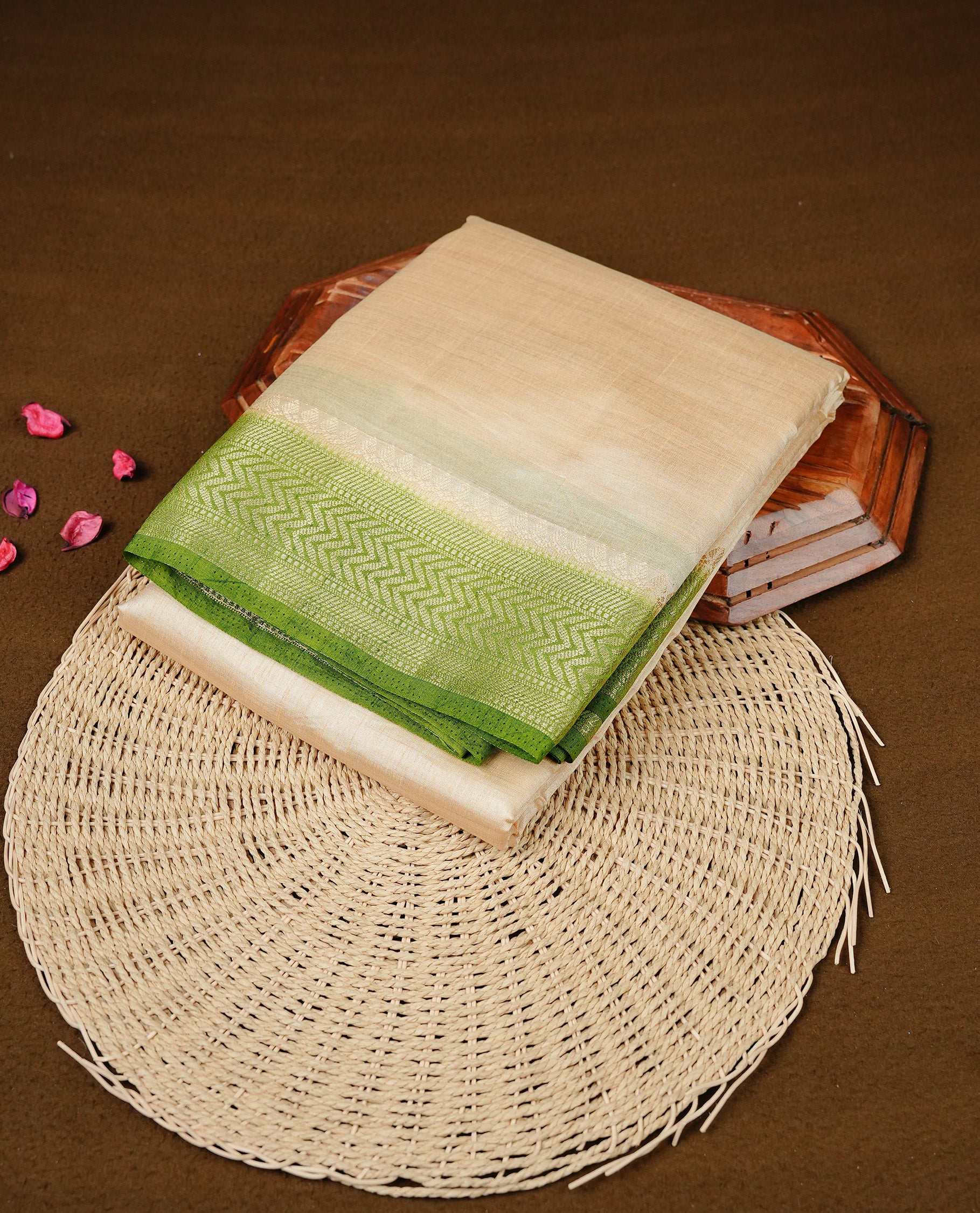 Cream colour Semi Tussar silk saree featuring an elegant plain body, accentuated by a contrast olive border adorned with intricate gold zigzag zari work, paired with a matching blouse piece.