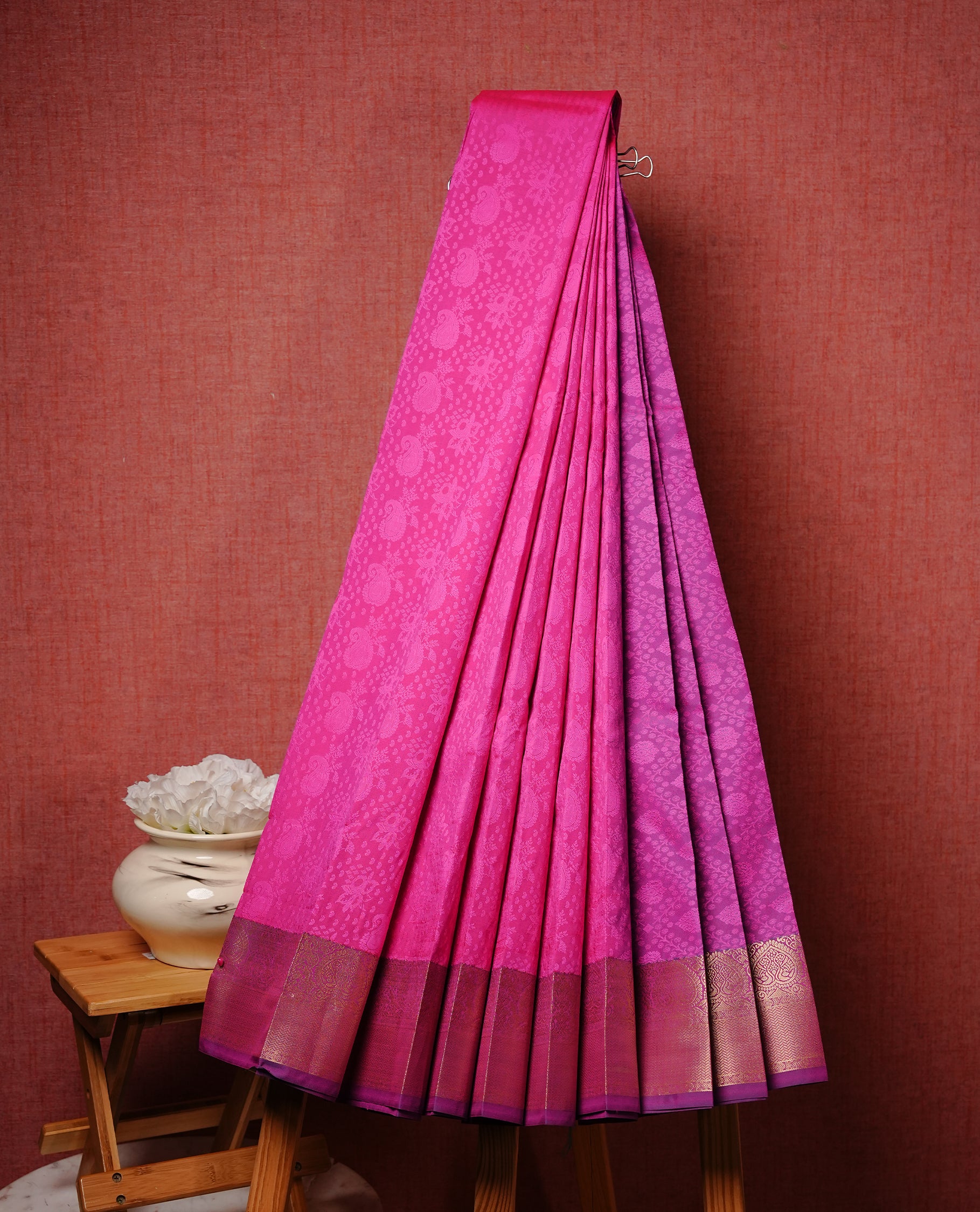 Bright Pink colour Semi silk saree Featuring Self colour zari motifs on body, complemented by contrast purple colour with gold zari border, paired with matching blouse piece.