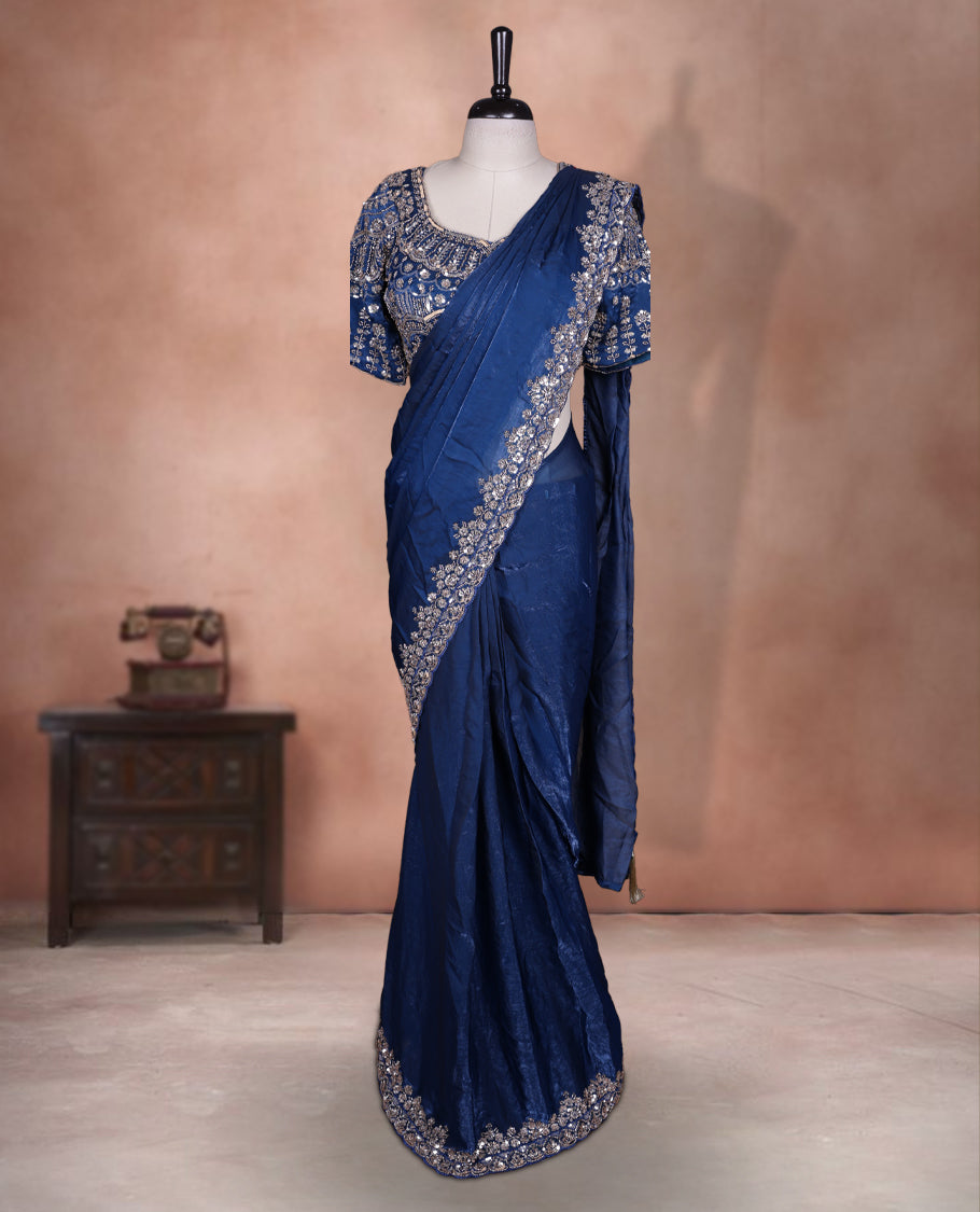 Elegant Dark teal colour ready to wear saree adorned with rich silver bead embroidery along the border and pallu, paired with a heavily embellished matching blouse for a grand festive look.