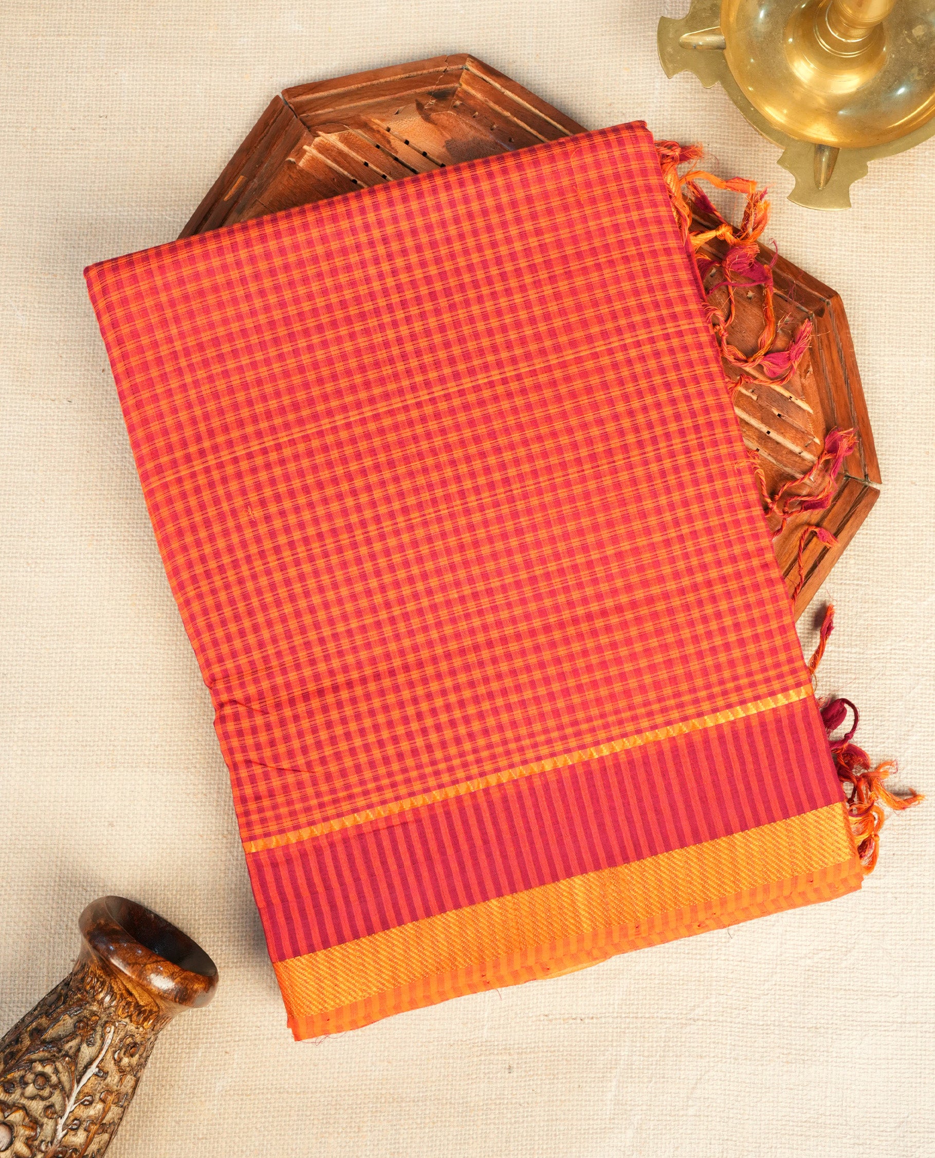 Orange Mangalagiri cotton saree featuring elegant Maroon Checks Pattern On Body, Complemented by Contrast Striped Pattern , Gold zari border & Contrast pallu, Paired With a matching blouse piece.