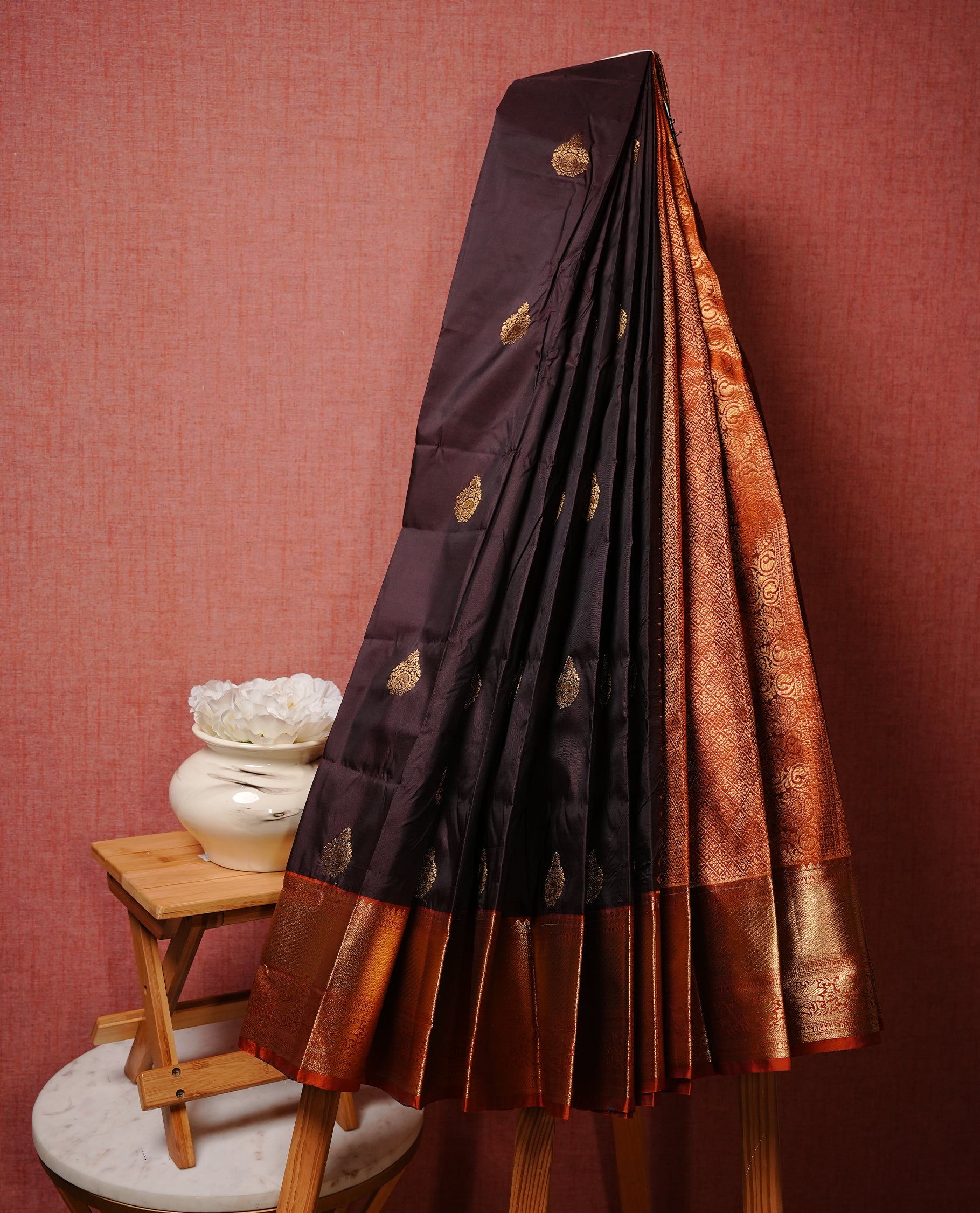 Dark chocolate colour Semi silk saree Featuring gold zari motifs on body, complemented by contrast Orange colour with gold zari border, paired with matching blouse piece.