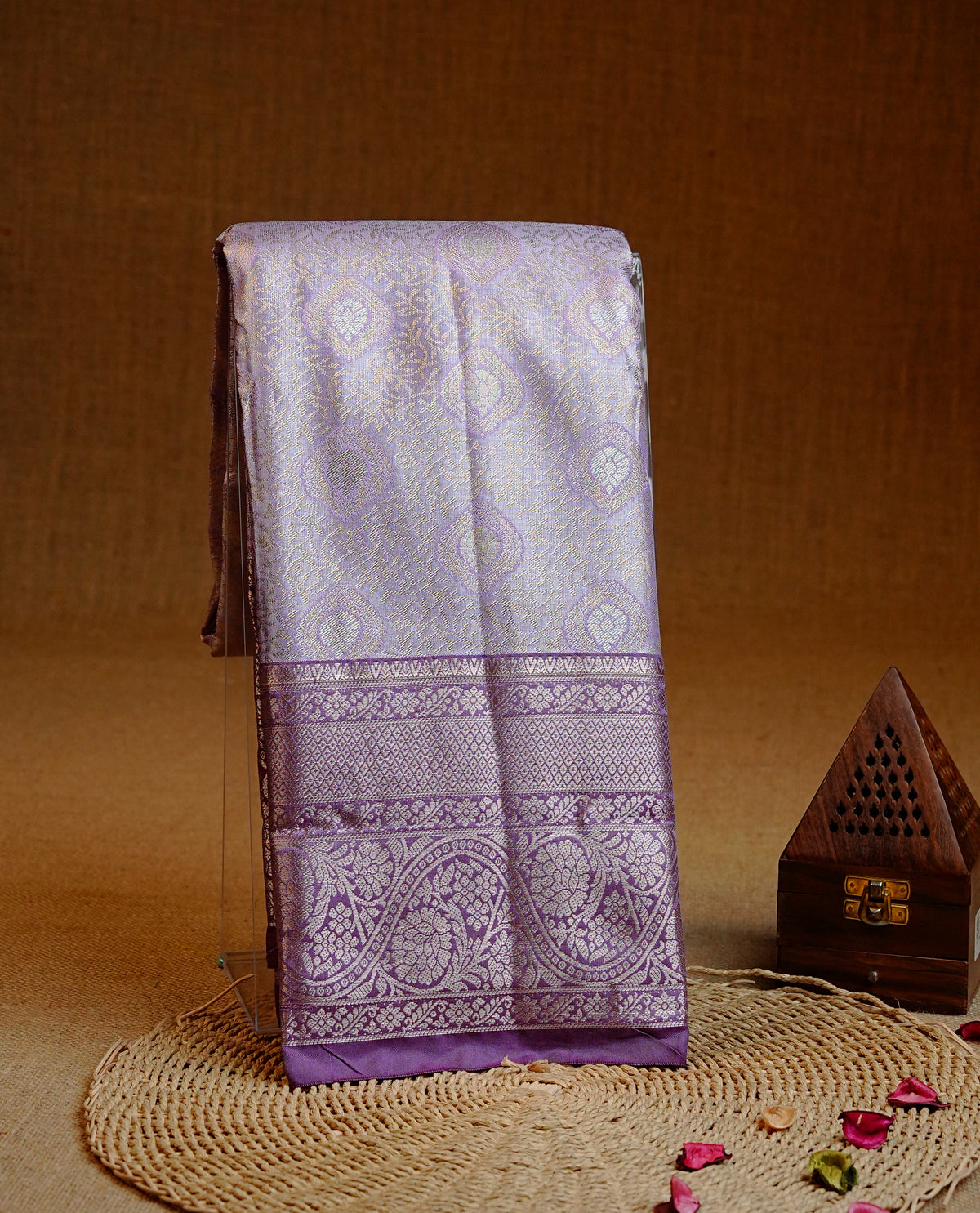 Lavender colour Semi tissue silk saree featuring Light gold zari kodi floral motifs on body, Contrast Purple colour with traditional border, paired with matching blouse piece.